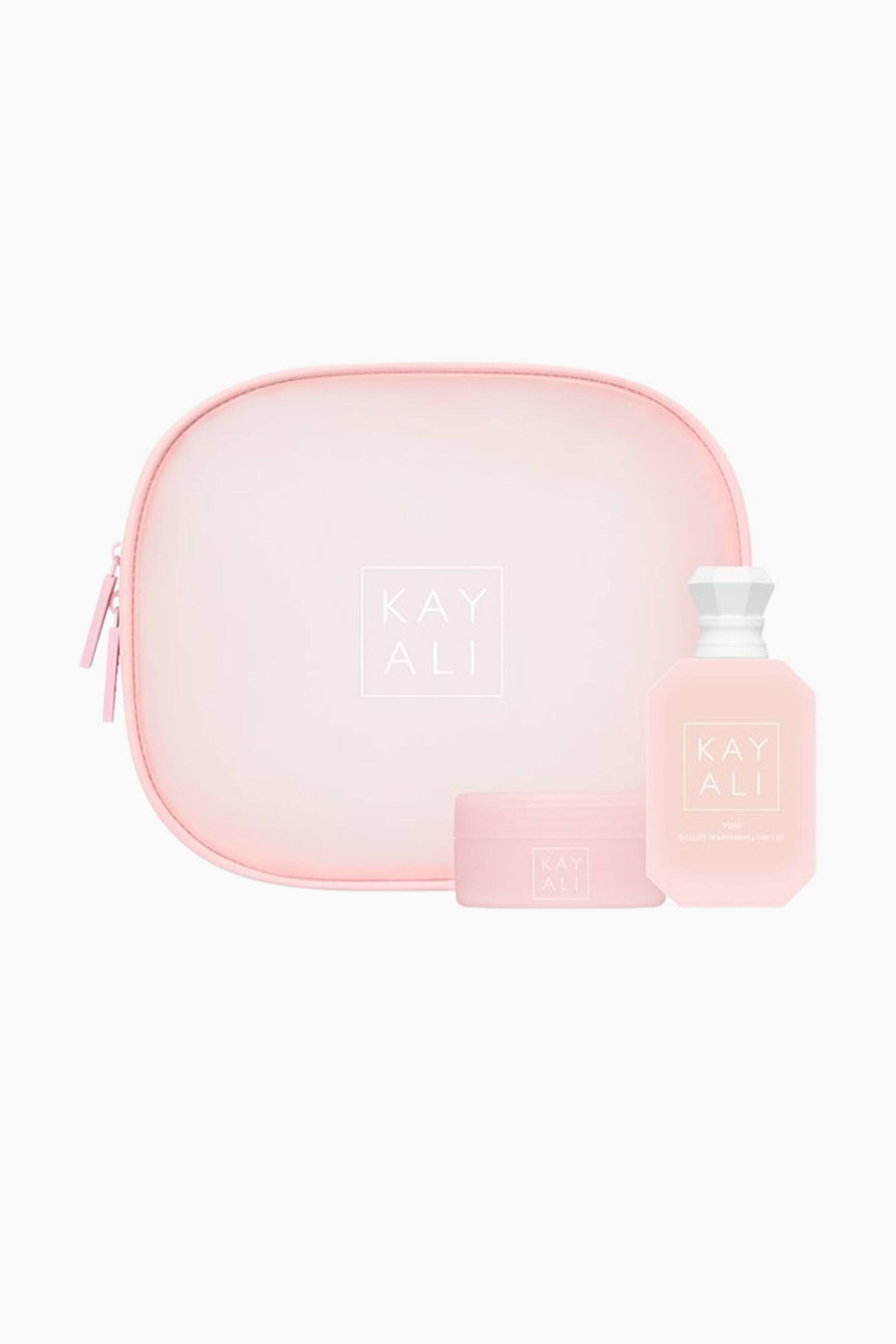 Näytä suurempi kuva: Yummy Dream Edp + Body Cream Set -setti esittelee vaaleanpunaisen, pyöreämuotoisen vetoketjullisen pussukan, jonka keskellä on valkoinen logo. Pussukan edessä on yhteensopiva vaaleanpunainen sylinterinmuotoinen purkki sekä kahdeksankulmainen hajuvesipullo, jossa on valkoinen fasetoitu korkki; molemmissa on sama valkoinen logo.