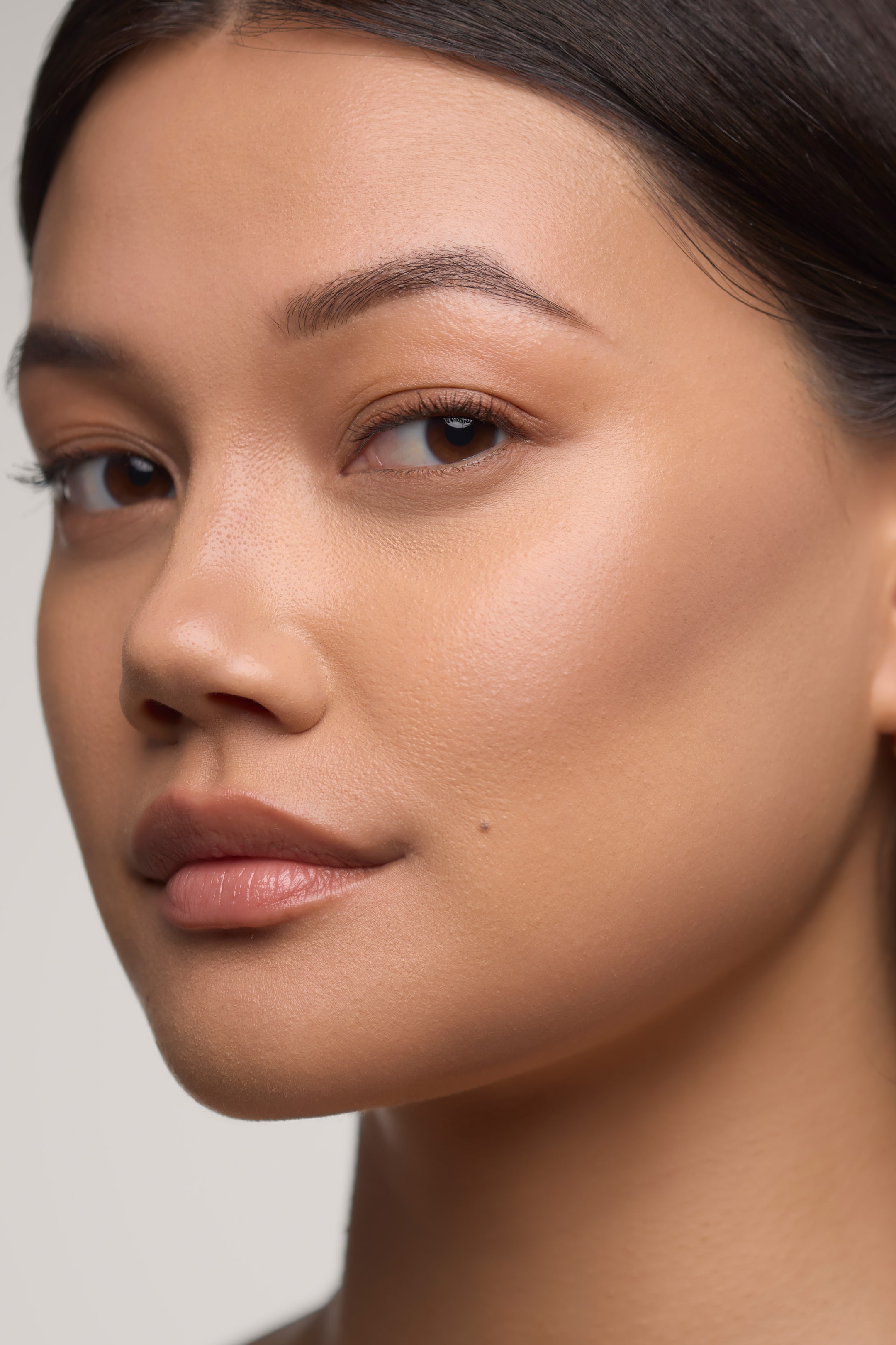 Vis større bilde: Morphe Shapelifter Micro Contour Stick demonstreres på ansiktet til en modell, og viser en utblendet kremkontur som fremhever og definerer kinnbeinet. Produktet gir en sømløs, naturlig finish som fremhever ansiktsstrukturen med en myk, matt tekstur.