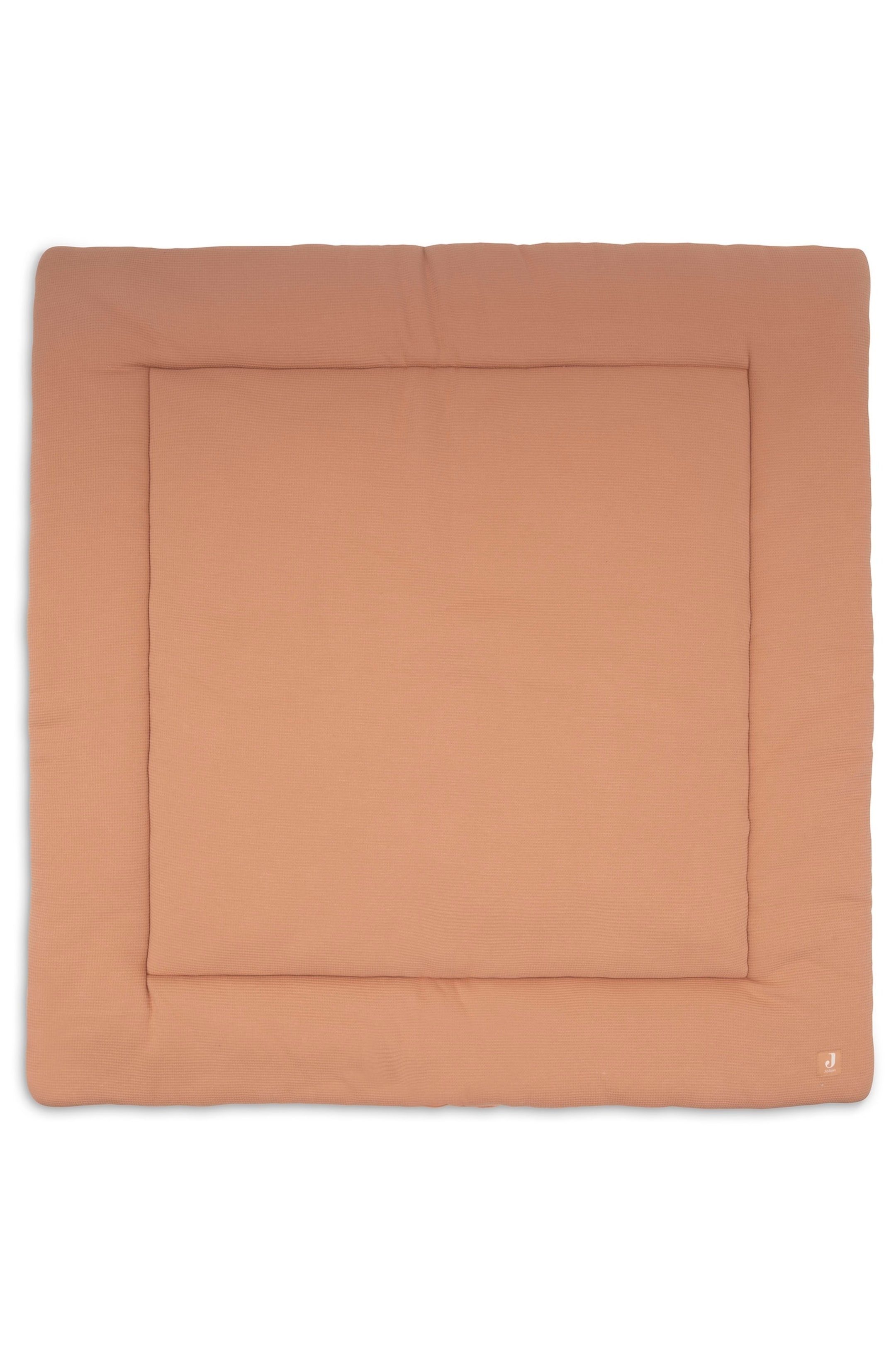 Agrandir l'image: Un tapis matelassé rectangulaire brun clair est posé à plat, présentant une texture subtilement côtelée à l'horizontale. Il se distingue par une bordure cousue distincte entourant un panneau central légèrement en retrait, avec un petit logo "J" visible dans le coin inférieur droit.