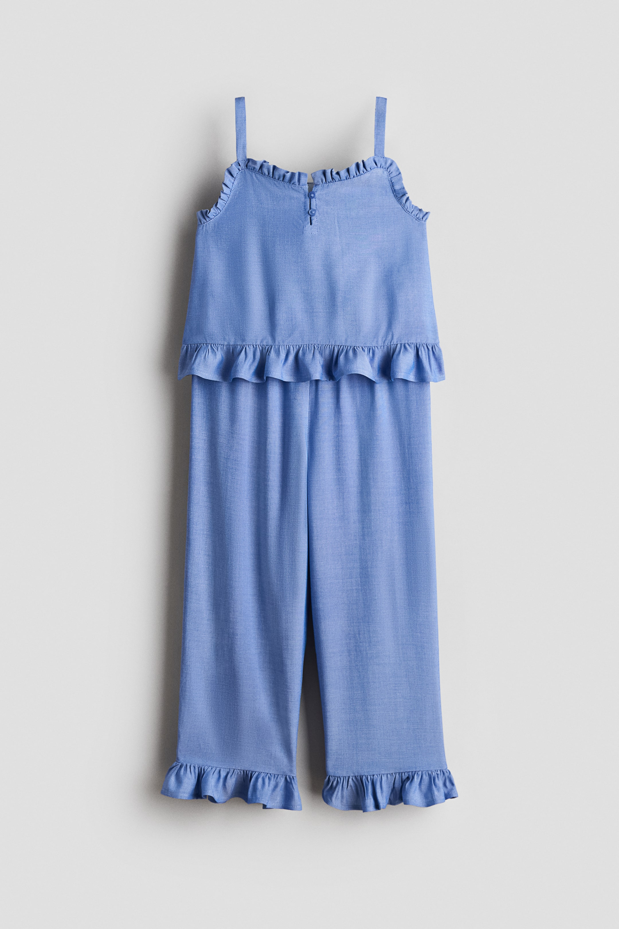 View larger image: A set featuring a top and matching trousers in light blue airy cotton seersucker is showcased from the front. The top highlights narrow shoulder straps, a square neckline with a keyhole opening and two buttons at the front, complemented by frill trim around the neckline and hem. The wide-leg trousers are detailed with frill-trimmed hems.
