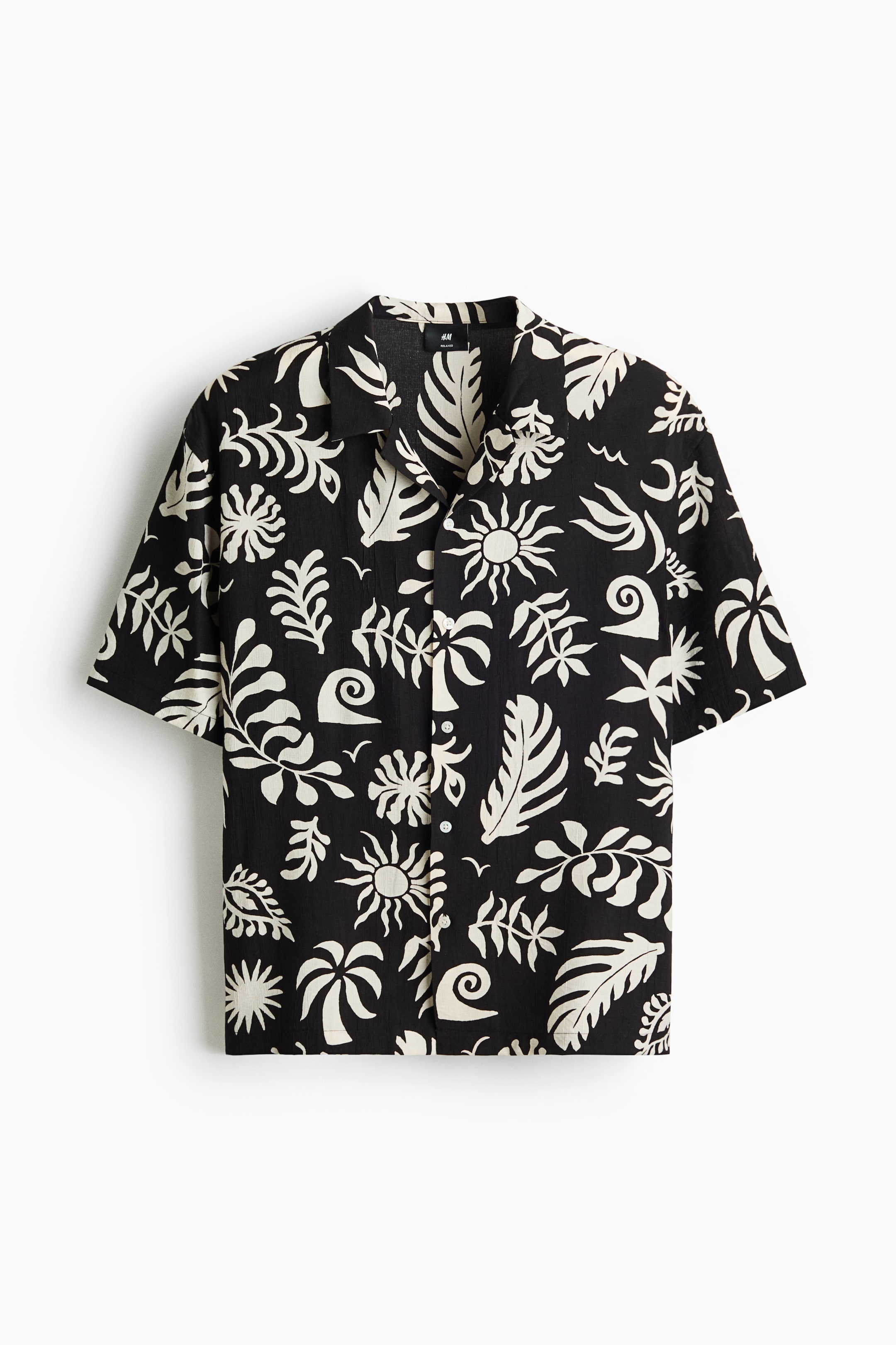 View larger image: A short-sleeved shirt is showcasing its front, featuring a black airy weave with an all-over off-white pattern of suns, tropical leaves, and wave-like shapes. It highlights a resort collar, a French front with visible buttons, short sleeves, and a straight-cut hem, offering a relaxed fit.