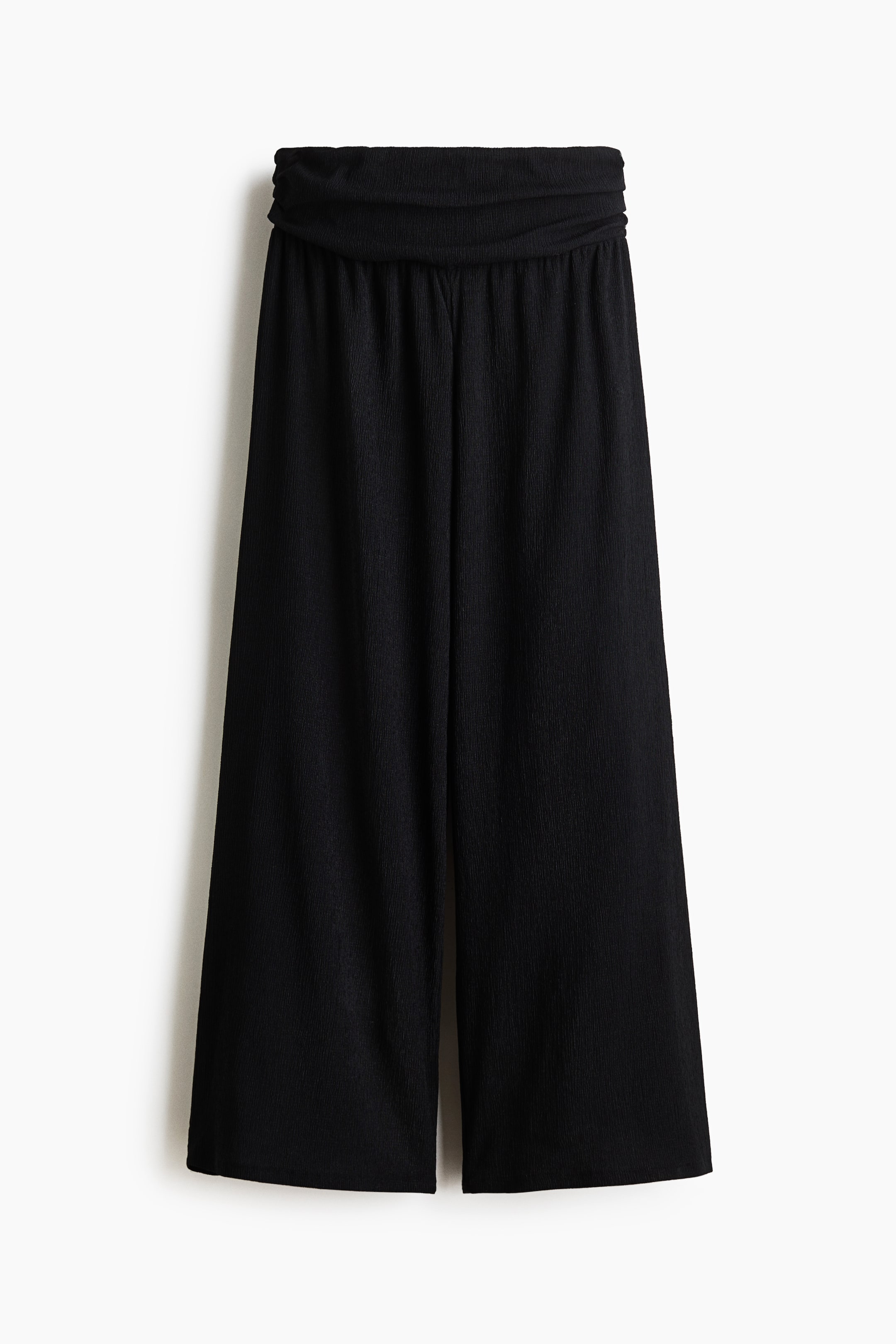 View larger image: Black wide-leg cropped pants are displayed from the front, showcasing a broad, ruched waistband and a subtle crinkled texture.