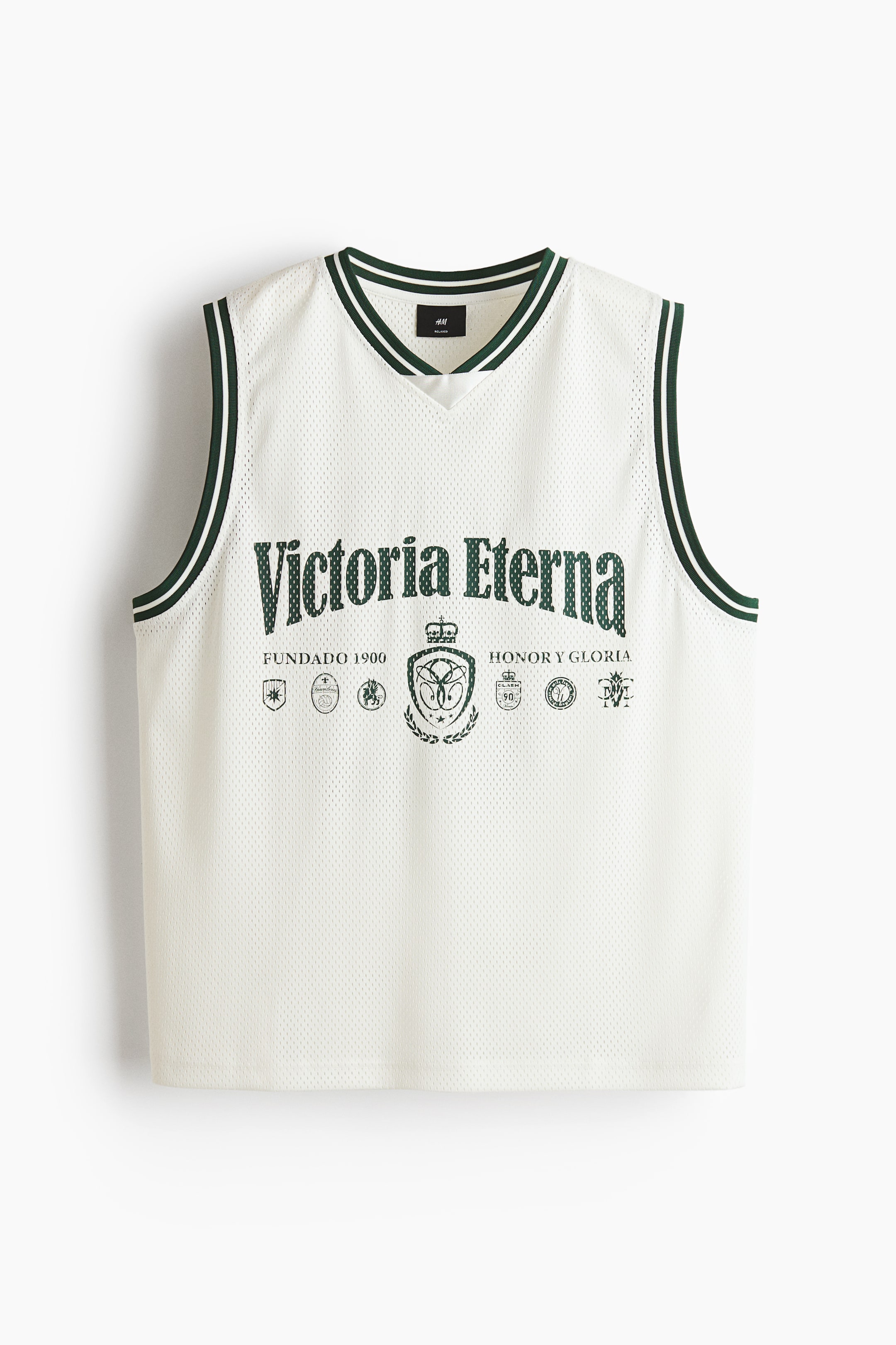 View larger image: The white mesh tank top showcases a V-neck and armholes trimmed in dark green with two thin white stripes. The front features "Victoria Eterna" in large dark green text, centered above a detailed crest design, accompanied by smaller text and circular emblems.