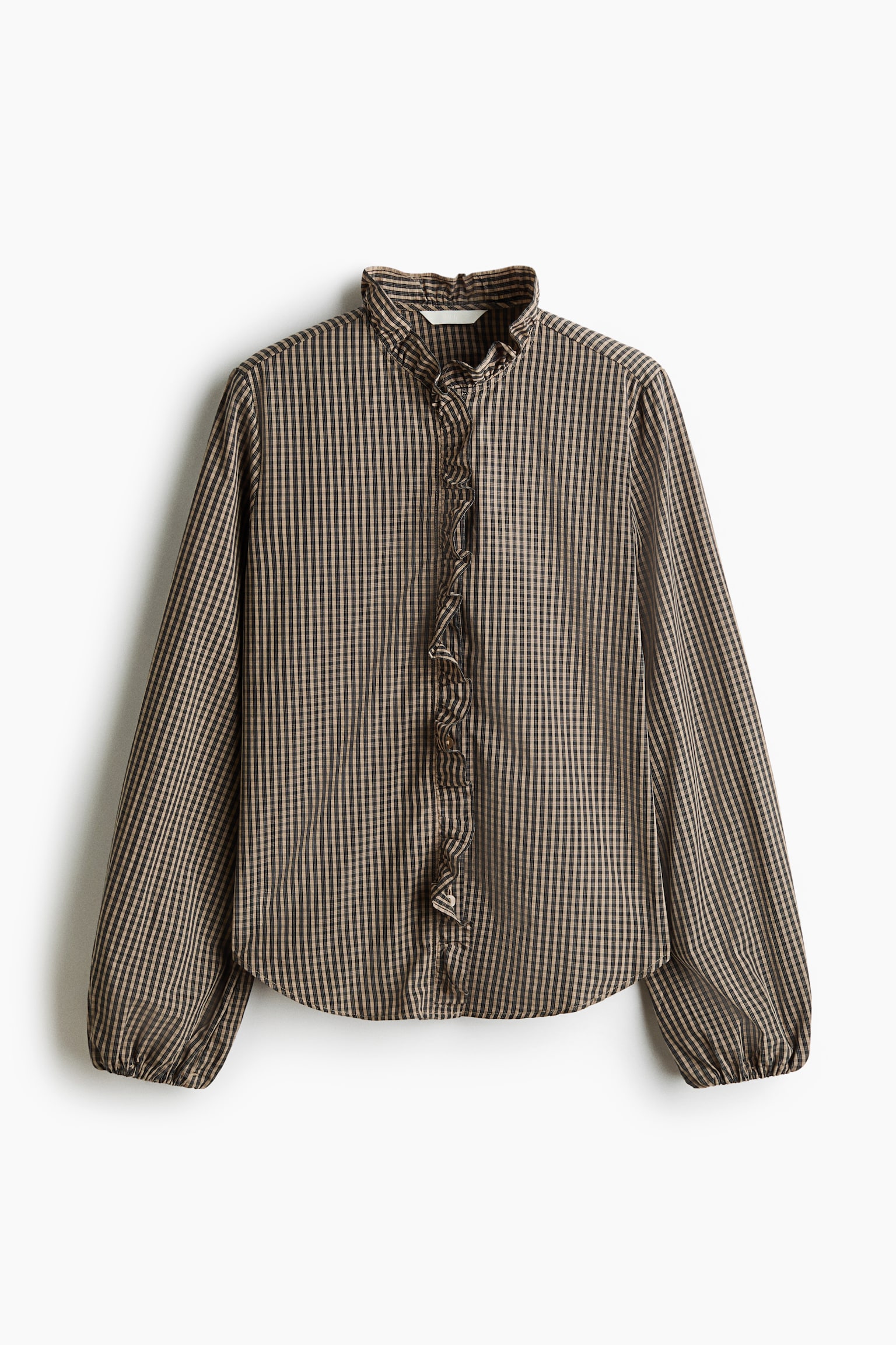 A front-facing long-sleeved blouse is displayed in a brown and black gingham pattern, featuring a ruffled stand collar and a ruffled trim along the centre button placket. The blouse has long sleeves with elasticated cuffs and a curved hem.