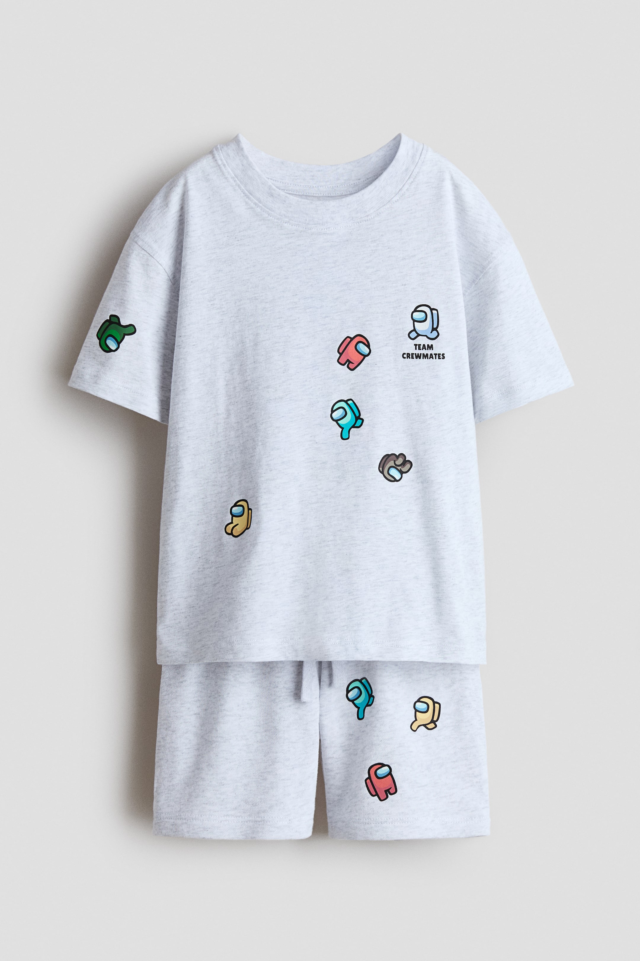 View larger image: A light gray marl printed set, facing FRONT, features a T-shirt with a round, rib-trimmed neckline, dropped shoulders, and colorful "Among Us" character prints along with "TEAM CREWMATES" text. The coordinating shorts have an elasticated, drawstring waist and matching character prints.