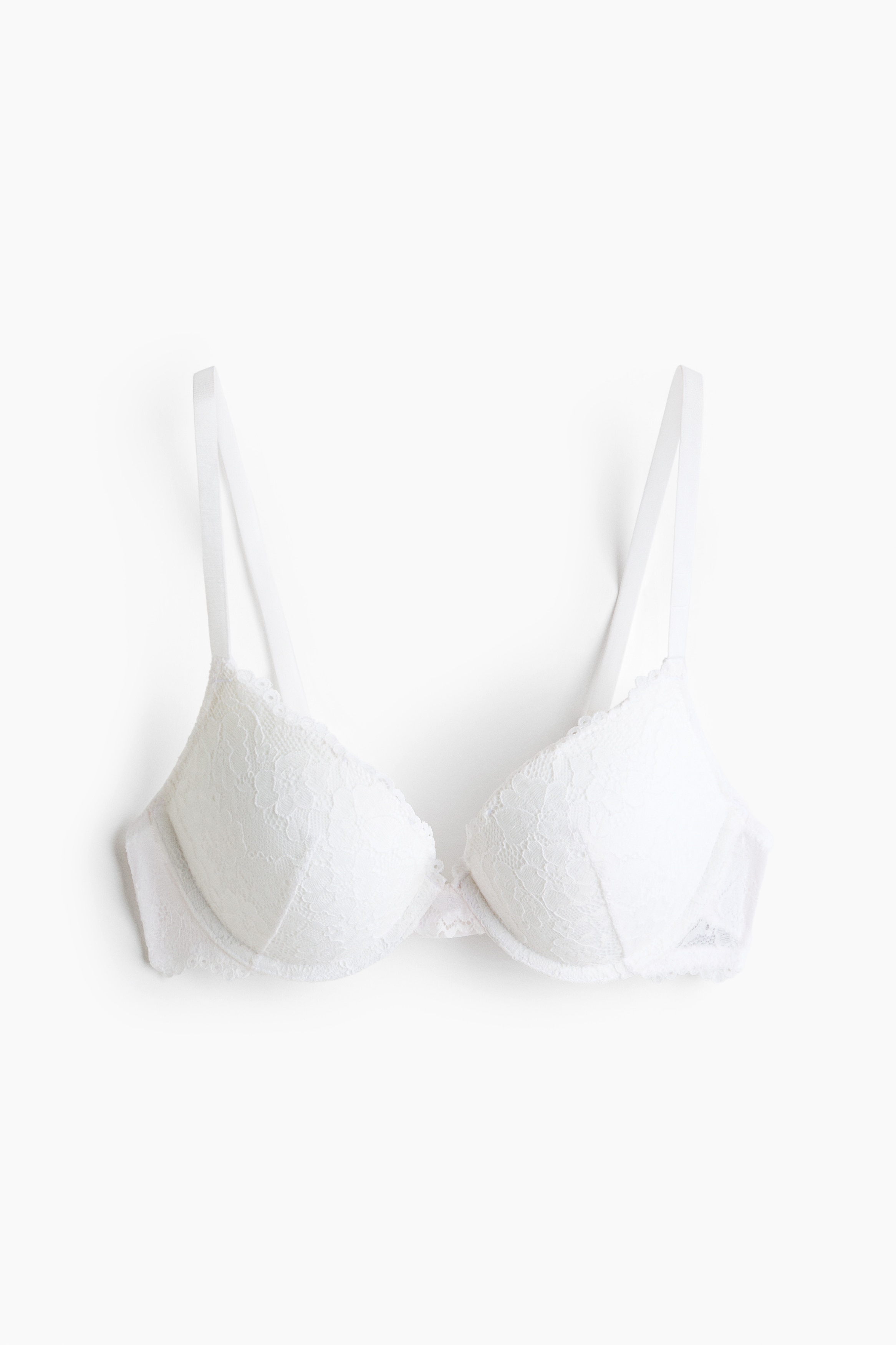 A push-up bra in white lace, featuring adjustable shoulder straps and underwired, padded cups, is being worn by the model. The model is also wearing white lace-trimmed underwear and relaxed-fit pants, completing a coordinated loungewear ensemble.
