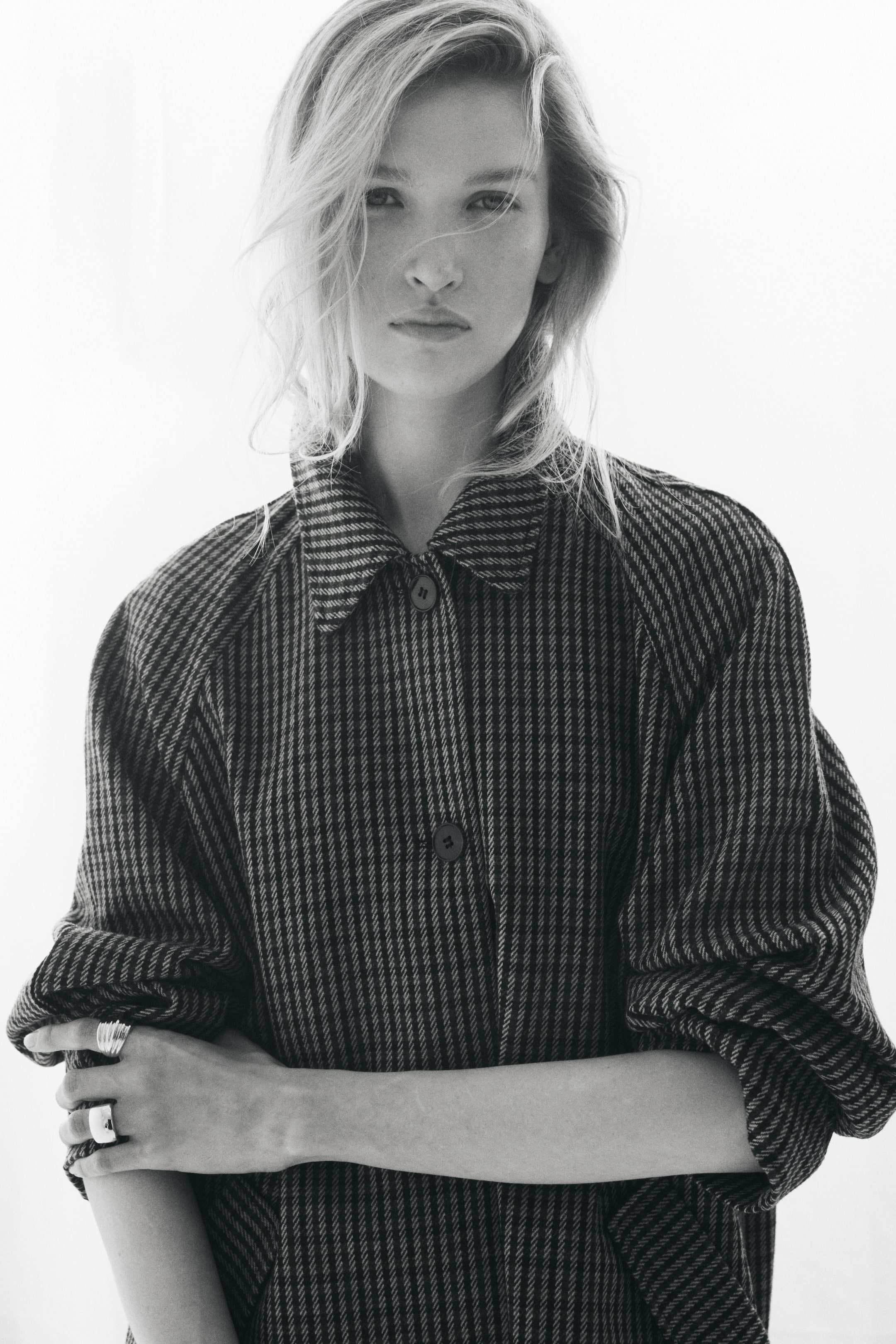 View larger image: A woven car coat featuring a textured vertical stripe pattern is shown from the front, highlighting its pointed collar, button-up front, and relaxed raglan sleeves.