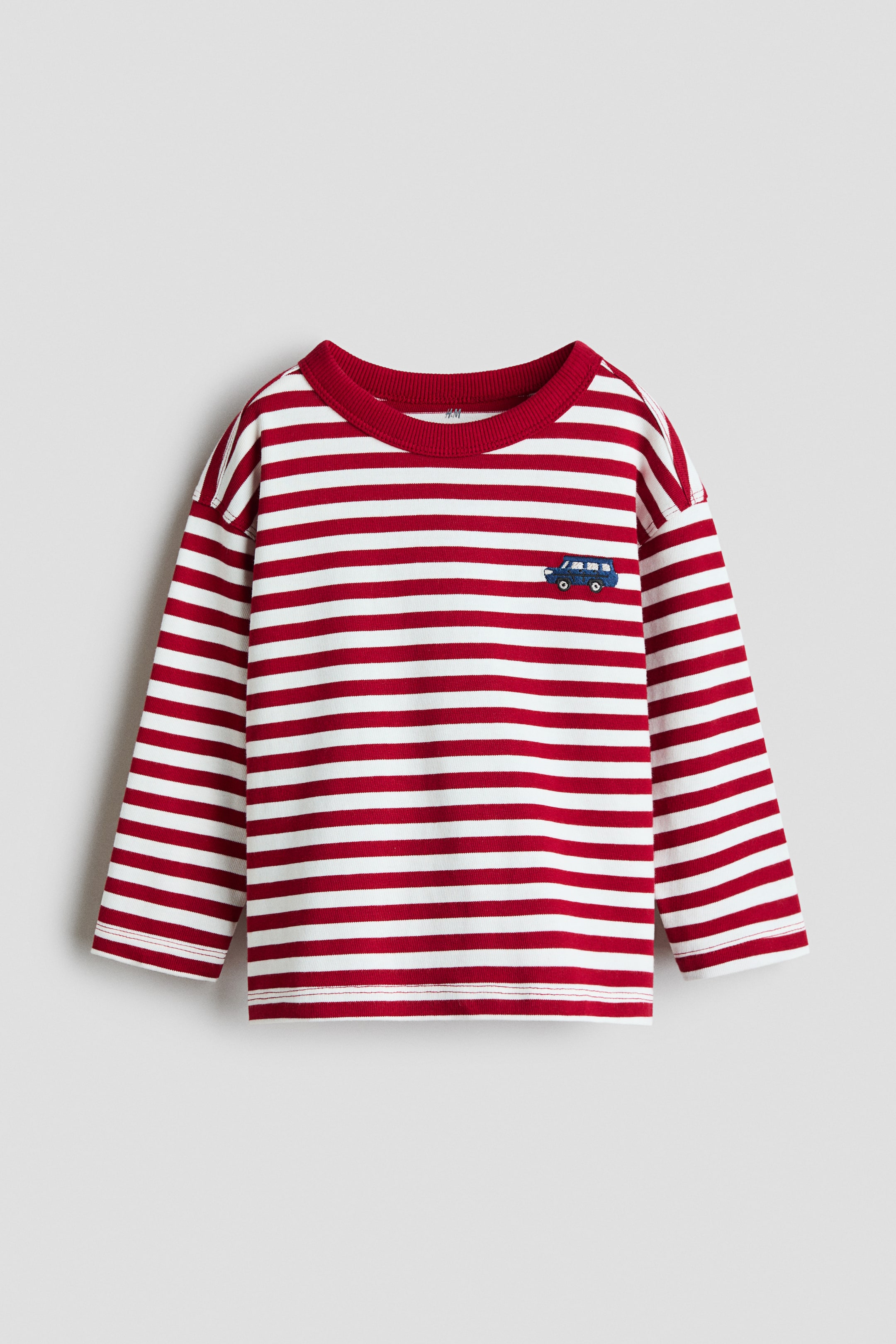 View larger image: A long-sleeved children's T-shirt shown from the front features alternating red and white horizontal stripes and a solid red ribbed crew neckline. The top features drop-shoulder sleeves and a small blue car embroidered on the left chest.
