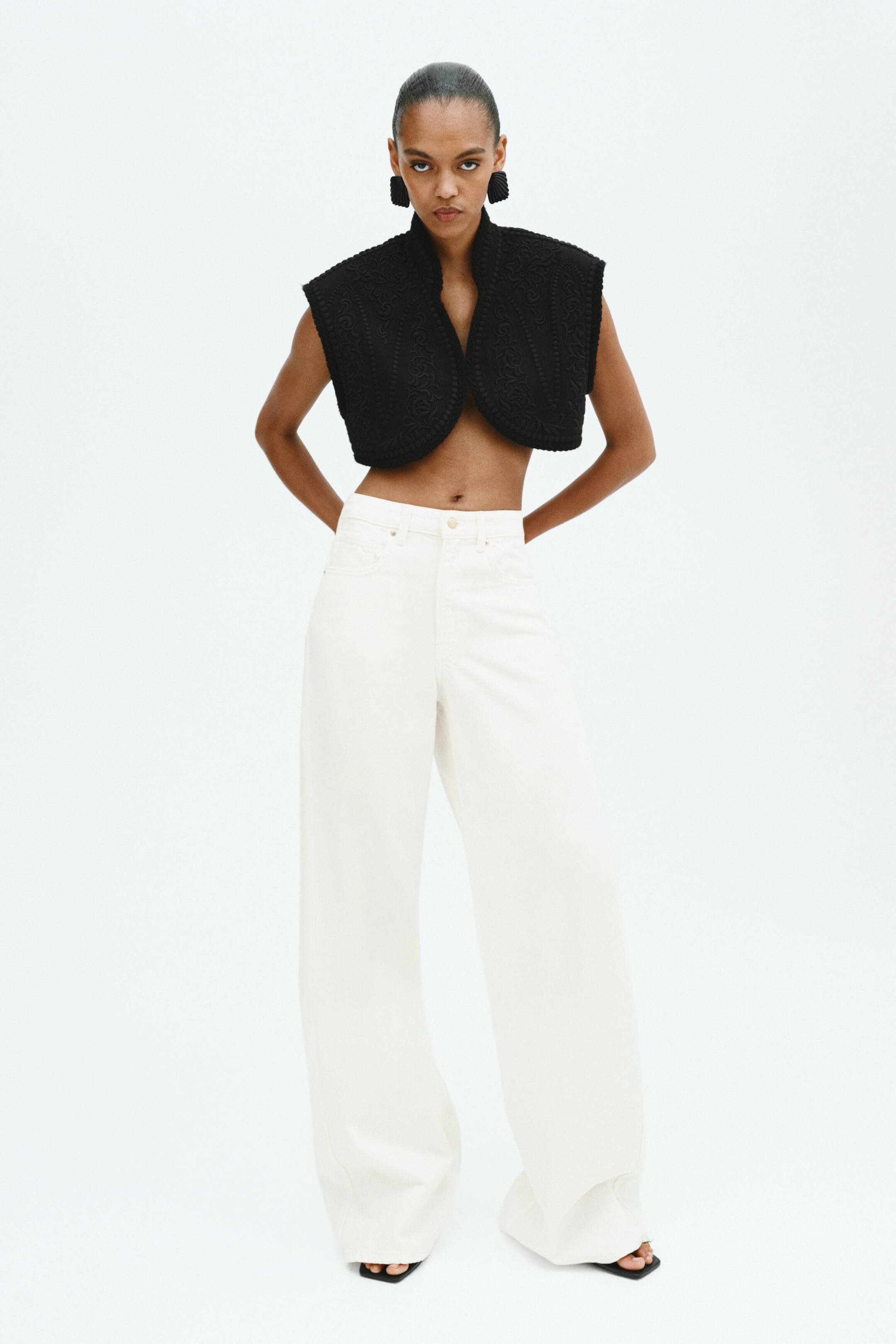 Visa större bild: Off-white 5-ficksjeans i styv denim bärs av modellen, med hög midja och vida ben. Jeansen har en normal passform från midjan till höften, med en vid skärning från låren till fållen, och är designade för att nå toppen av foten.