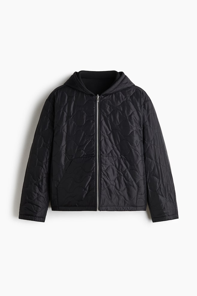 Eine schwarze Kapuzenjacke ist von vorn zu sehen und verfÃ¼gt Ã¼ber ein gesteppte Ripstop-Gewebe mit Zwiebelmuster. Das Design umfasst einen mittig platzierten silbernen ReiÃverschluss, Ã¼berschnittene Schultern und schrÃ¤g angesetzte Front-Einschubtaschen. - 1