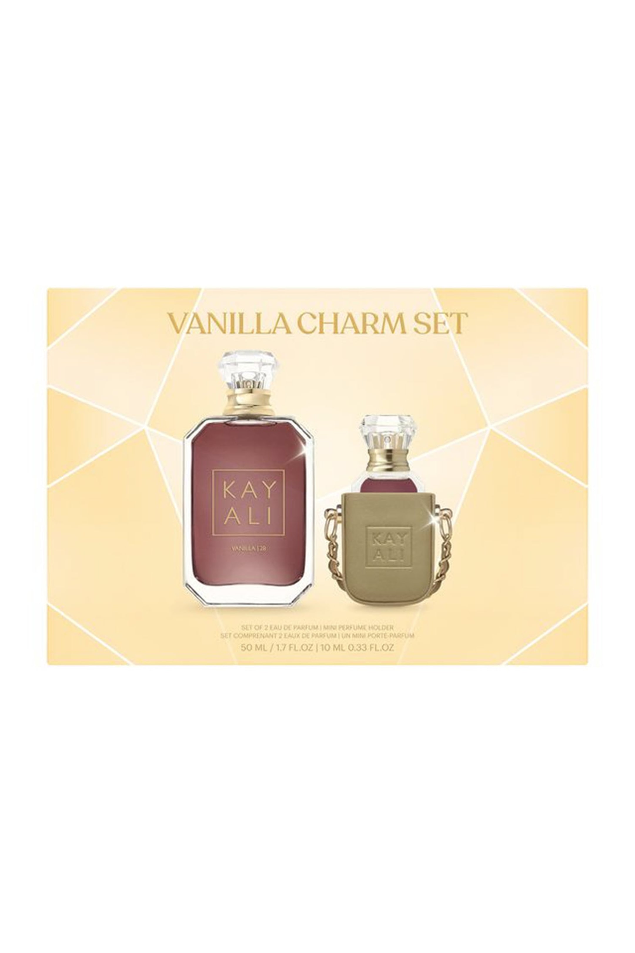 Näytä suurempi kuva: Kayali Vanilla Charm Set -pakkauksessa esitellään 50 ml:n facettihiottu lasipullo Vanilla | 28 Eau de Parfum -tuoksua sekä sen rinnalla 10 ml:n miniatyyri pullo, joka on asetettu kullanväriseen charmipidikkeeseen ketjuineen. Molemmissa pulloissa on meripihkanvärinen neste, kultasävyiset kaulat ja kirkkaat, timantinmuotoiset tulpat.