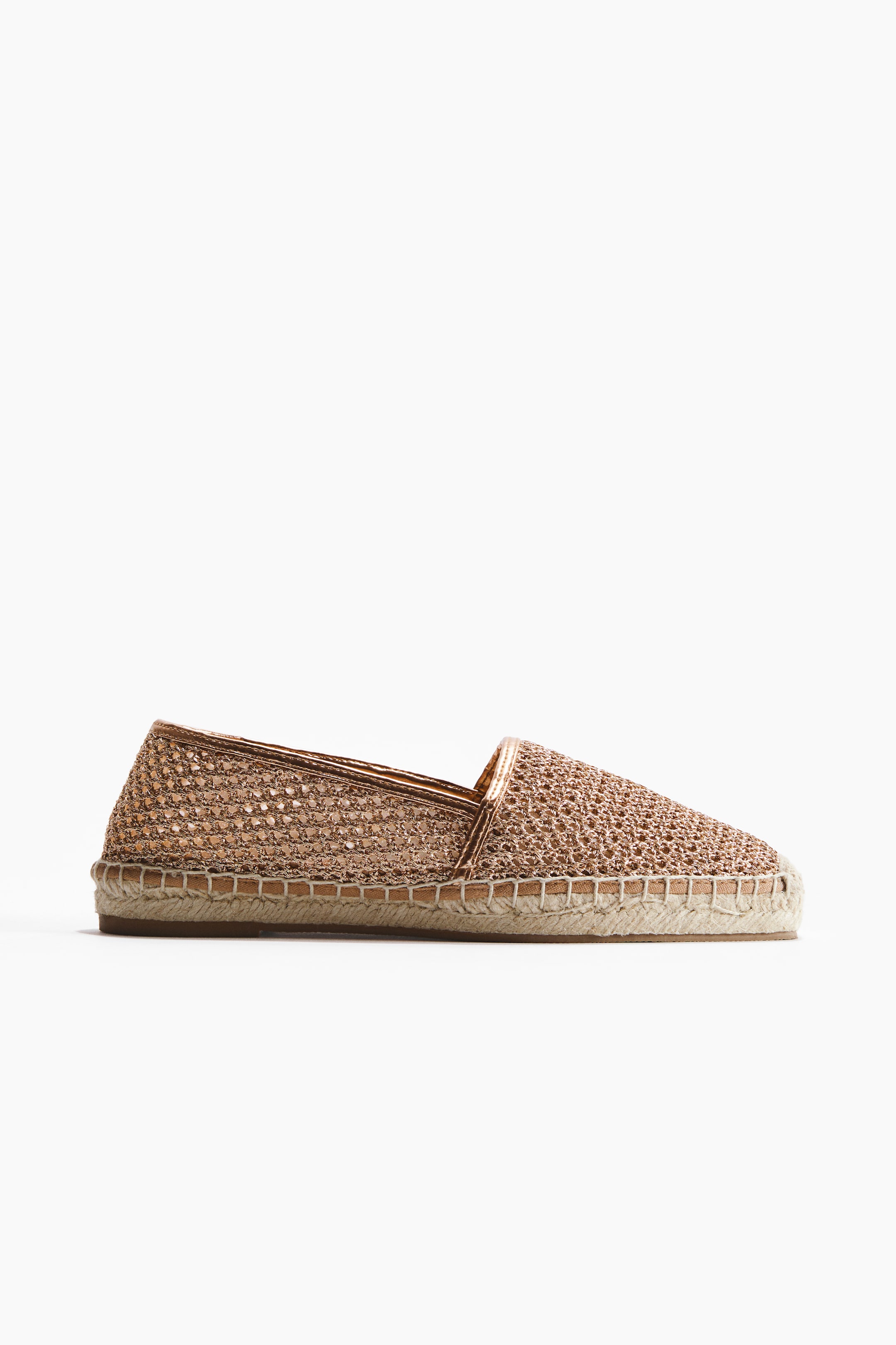 Agrandir l'image: Une espadrille est présentée en profil latéral, avec une tige en paille plastique tressée de couleur bronze métallique et une bordure métallique assortie autour de l'ouverture. Elle est conçue avec un bout carré et est finie avec une bordure en jute tressée autour des semelles.