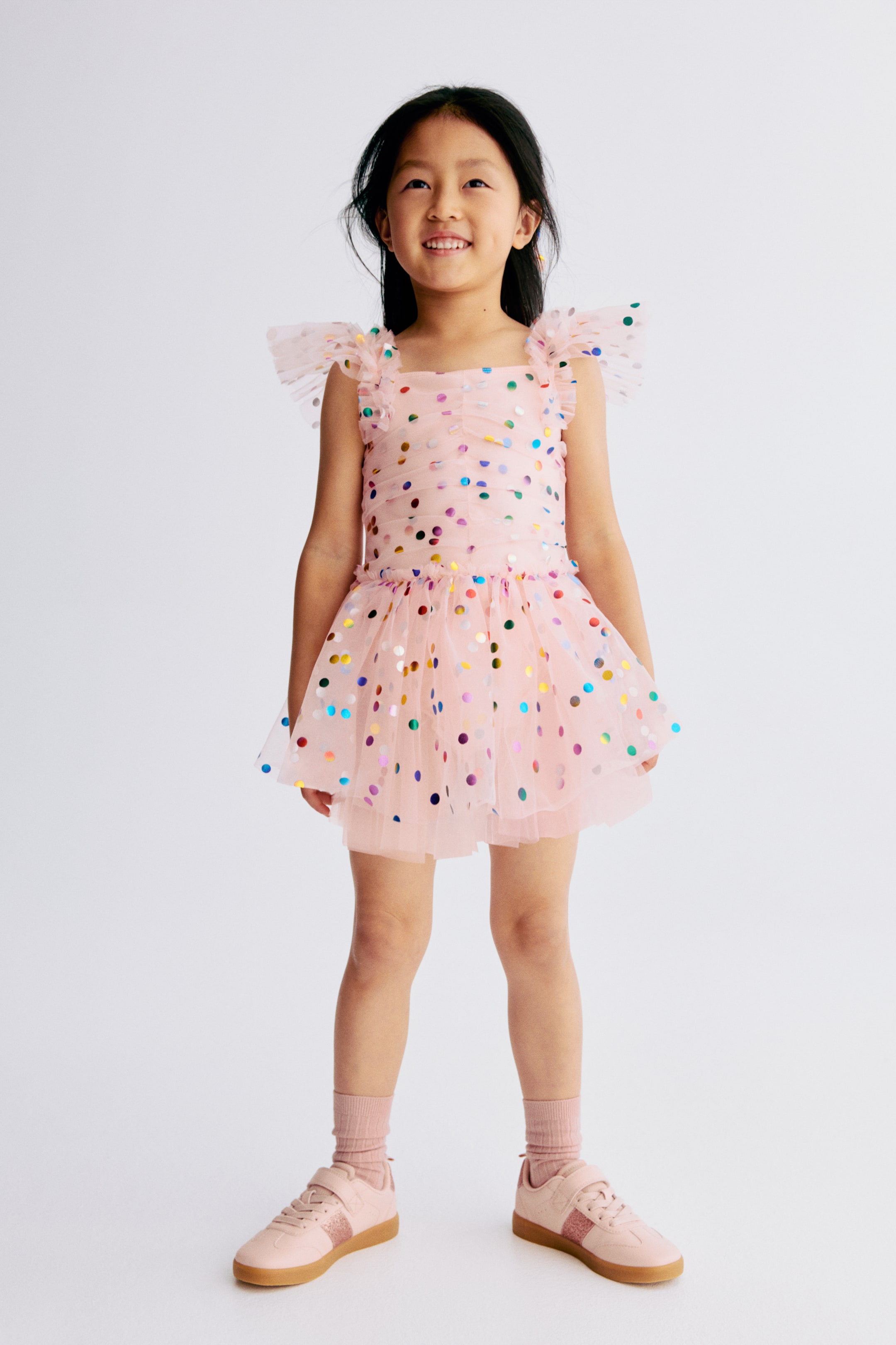 Ampliar la imagen: Un vestido con el frente hacia adelante está hecho de tul impreso en papel de aluminio, con un body cosido en jersey suave. Presenta un escote cuadrado, tirantes con elásticos cubiertos detallados con volantes, una costura vertical fruncida en la parte delantera del corpiño y una falda acampanada en varias capas de tul.