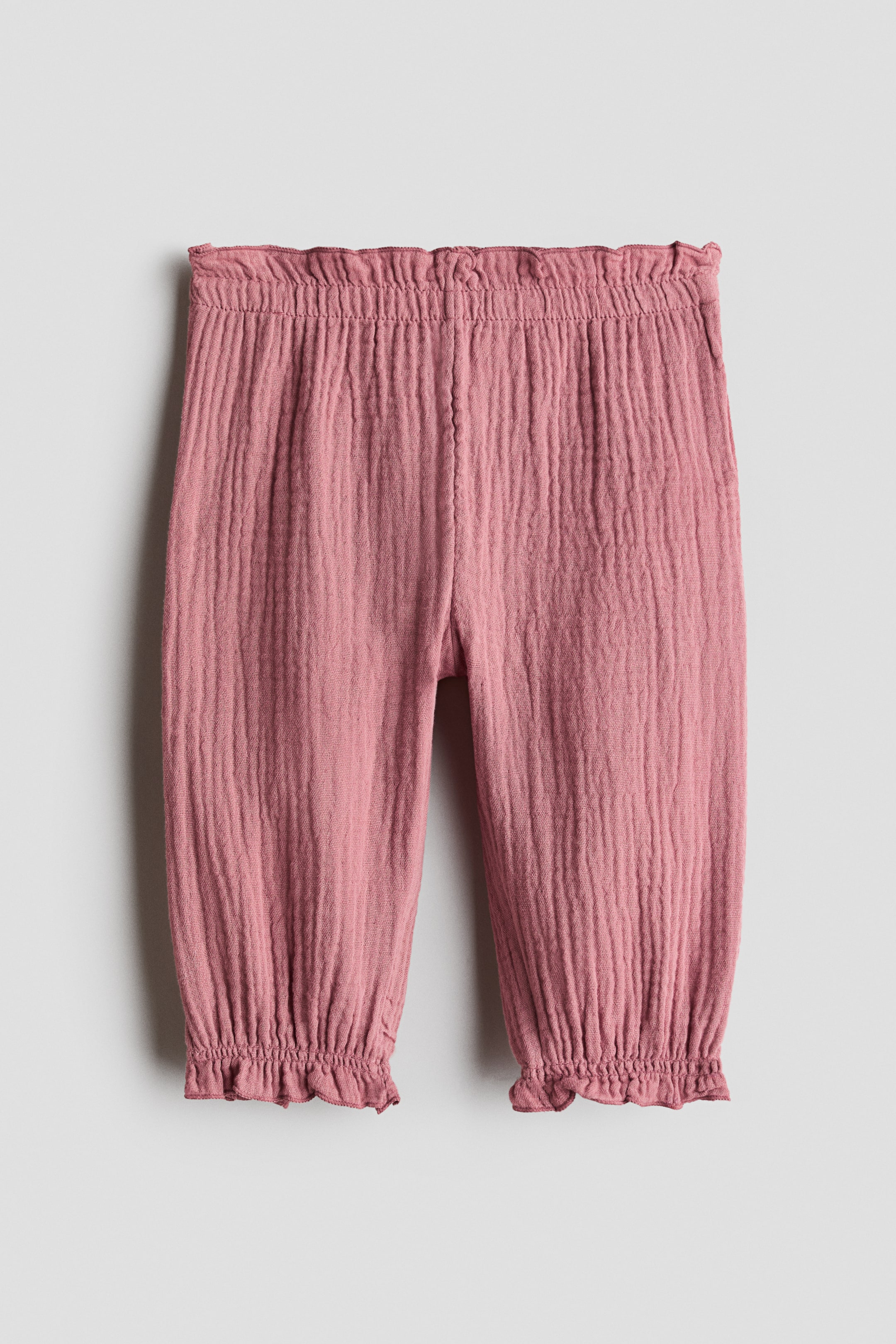 Grösseres Bild ansehen: Staubrosa Hosen mit geknitterter Textur, einem gesmokten elastischen Bund und gerüschten elastischen Bündchen.