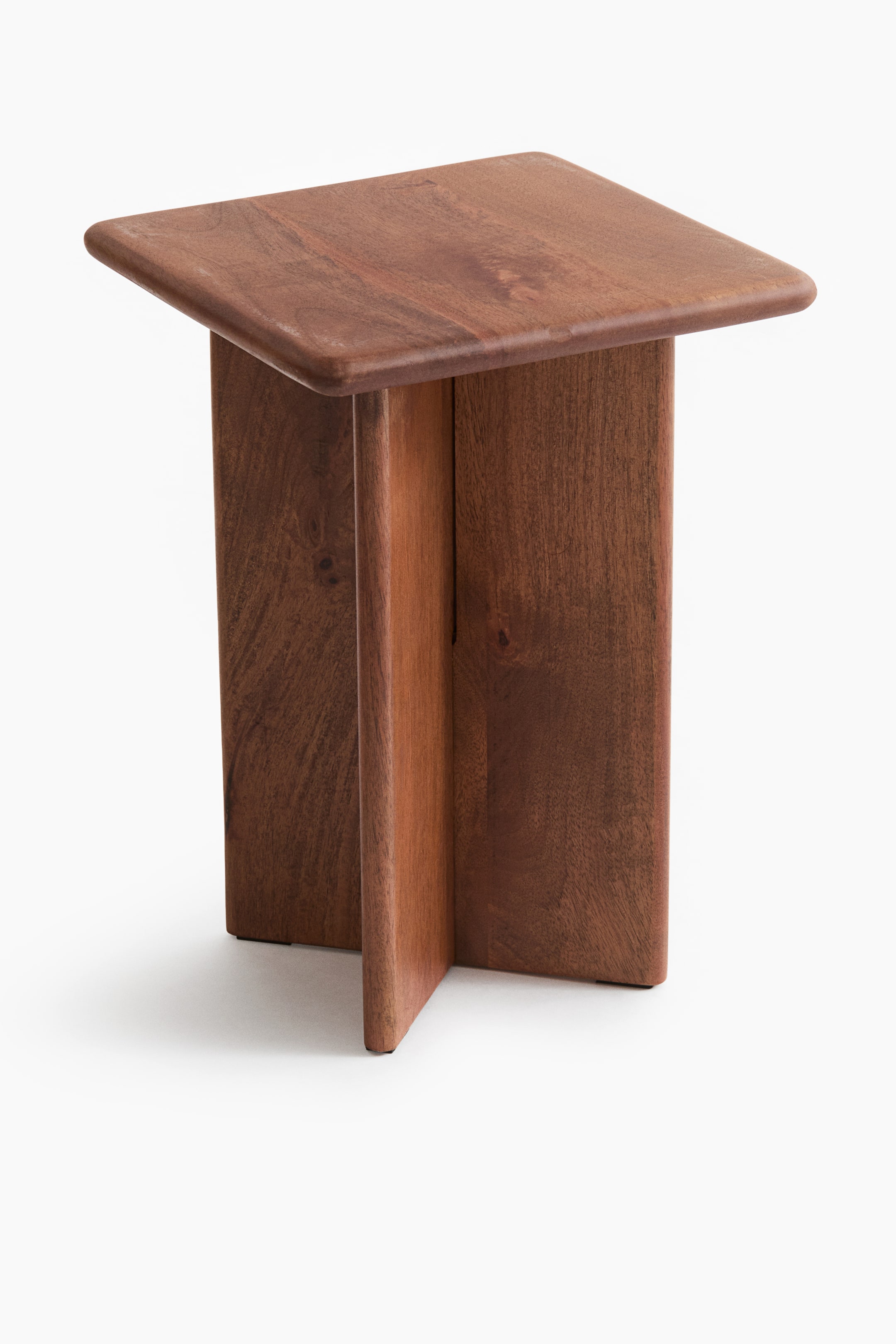 View larger image: A square side table crafted from medium-brown wood is shown from a high three-quarter angle, featuring a thick tabletop with smooth, rounded edges and corners. The table is supported by a cross-shaped pedestal base made of intersecting vertical wooden panels that highlight the natural grain.