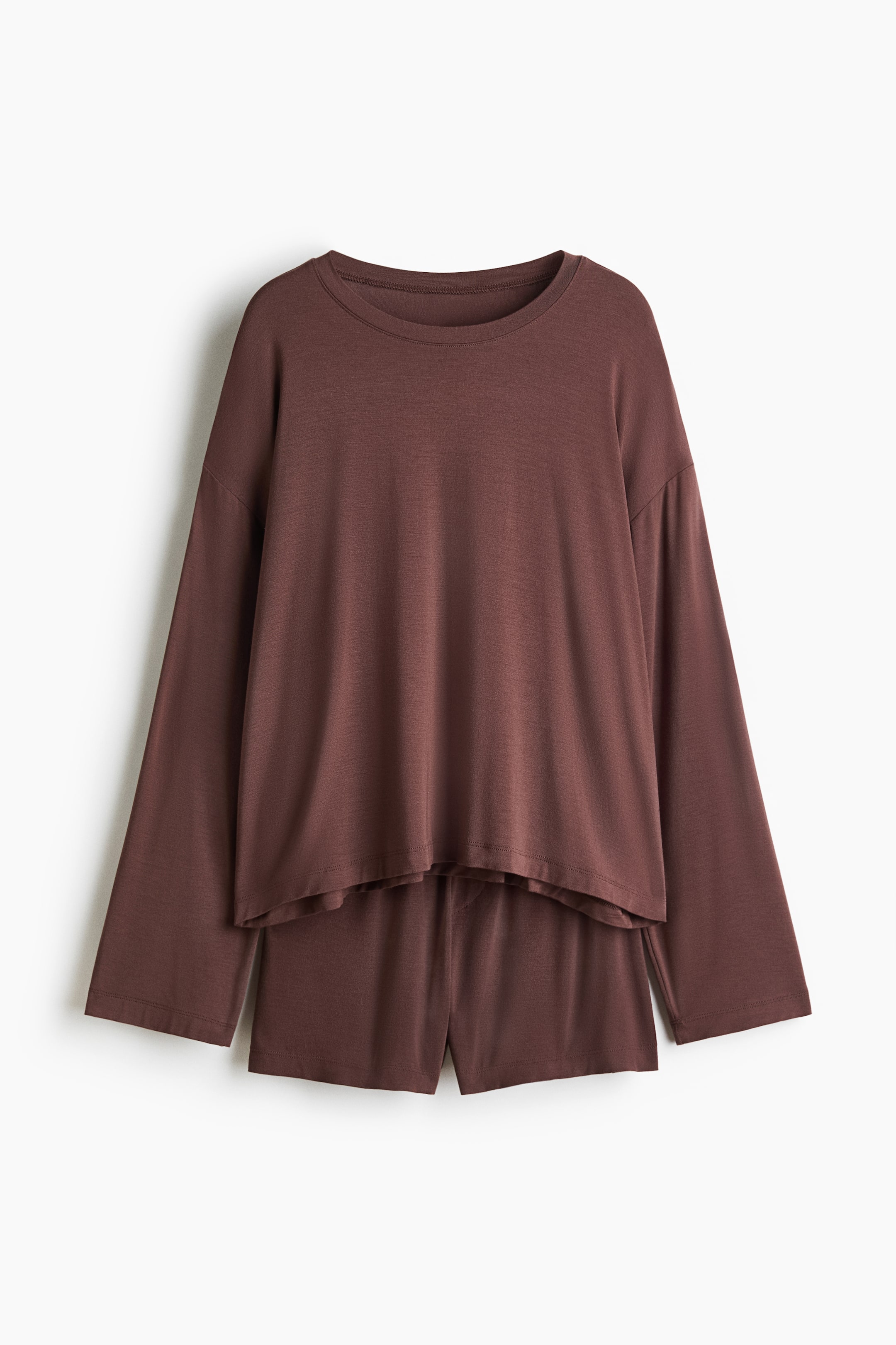Ampliar la imagen: Un conjunto de pijama marrón se muestra de frente, compuesto por un top y unos shorts. El top presenta cuello redondo, hombros caídos y mangas largas. Los shorts presentan cintura elástica y bragueta falsa.