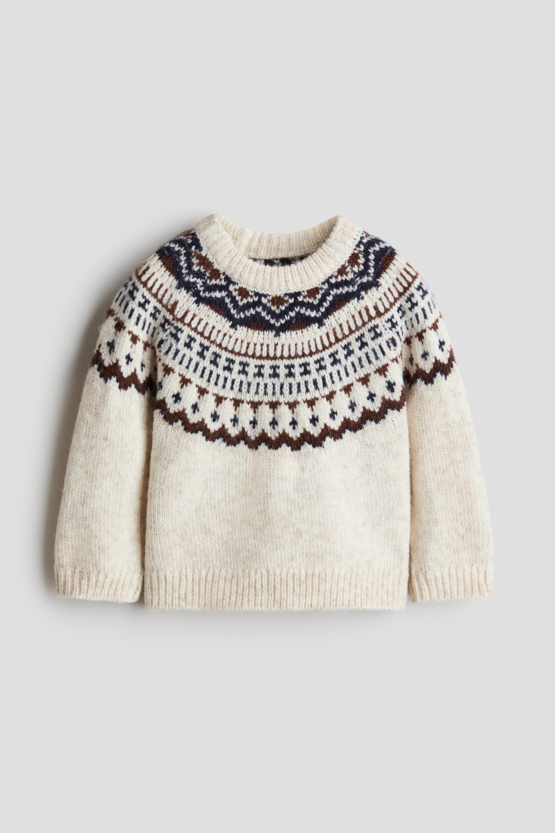 Größeres Bild anzeigen: Ein cremefarbener Pullover zeigt ein dunkelblaues und braunes Fair-Isle-Muster rund um die Passe. Er verfügt über einen gerippten Rundhalsausschnitt, gerippte Ärmelbündchen und einen gerippten Saum.