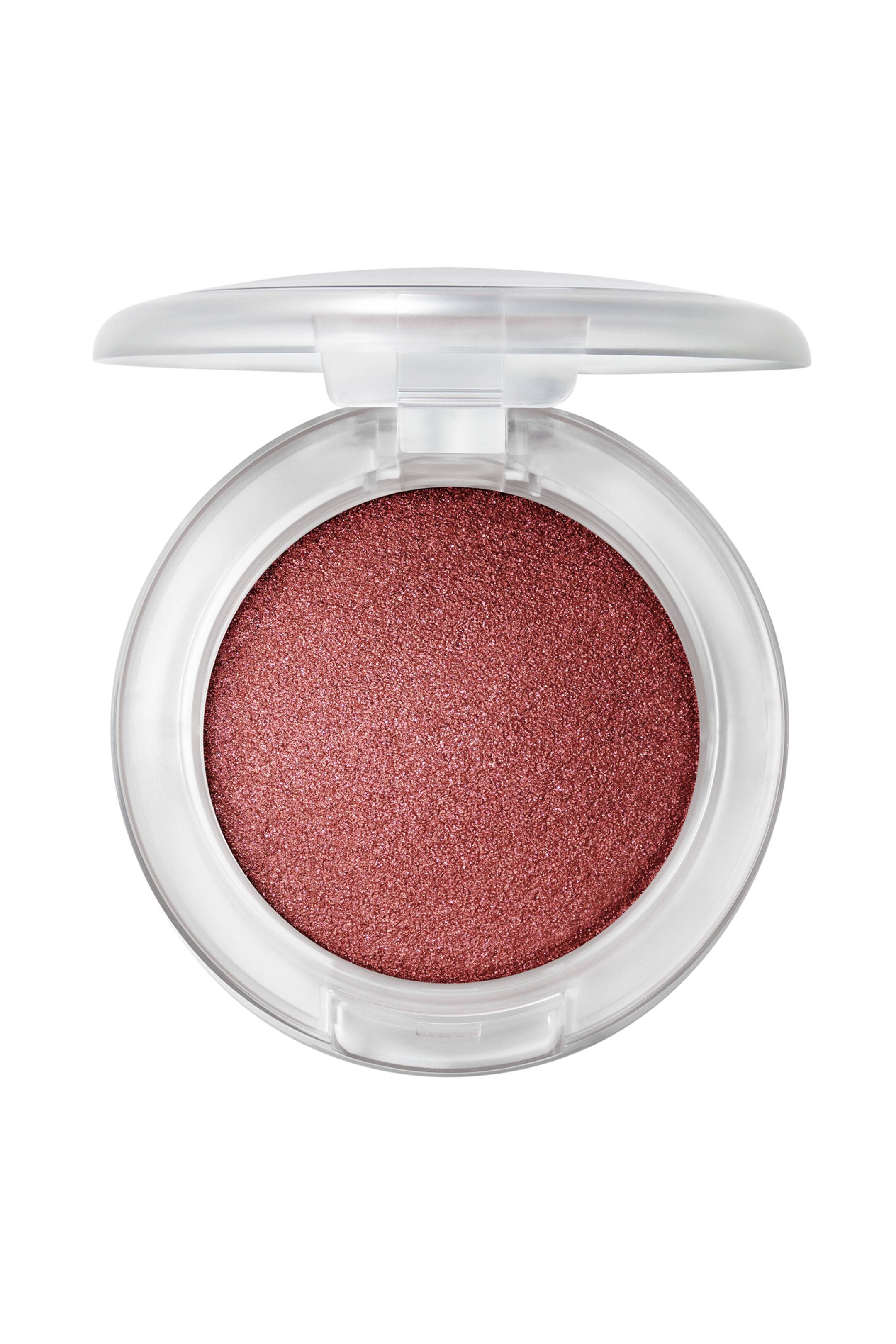 Visa större bild: Glow Play Bouncy Highlighter visas i en öppen, cirkulär, genomskinlig dosa som är riktad rakt framåt. Dosan har en rund pan med skimrande, kupolformad highlighter i rosékoppar med en fint texturerad, gnistrande finish.