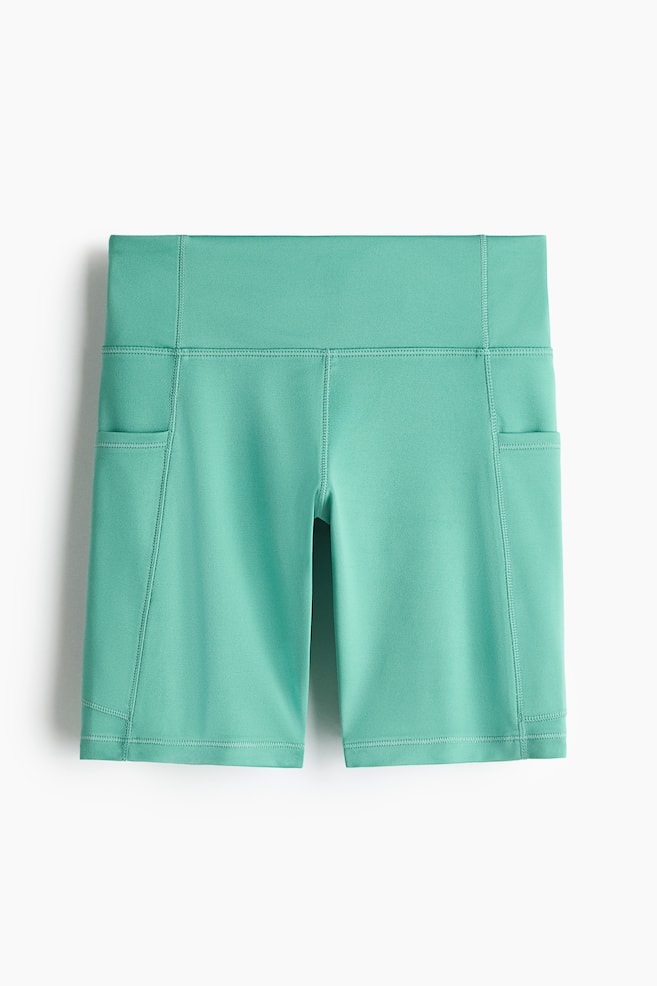 Mint green sports cycling shorts with DryMove? are displayed from the front, showcasing a broad waistband, flatlock seams, and side pockets on each leg. - 1