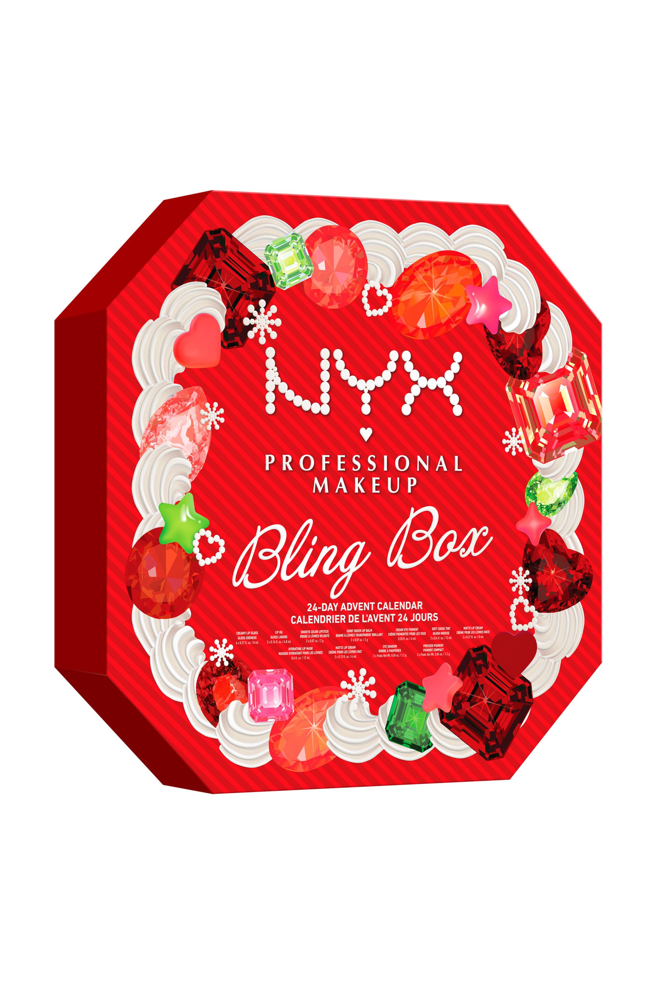 Visa större bild: NYX Professional Makeup Bling Box-adventskalendern står i en trekvarts vinkel och visar upp sin röda oktagonala form och sidodjup. Framsidan visar en cirkulär krans av spritsad vit glasyr dekorerad med färgglada imitationstenar, hjärtan, stjärnor och snöflingor, som omger varumärkesnamnet utstavat i vita pärlor och texten "Bling Box" i vit kursiv stil.