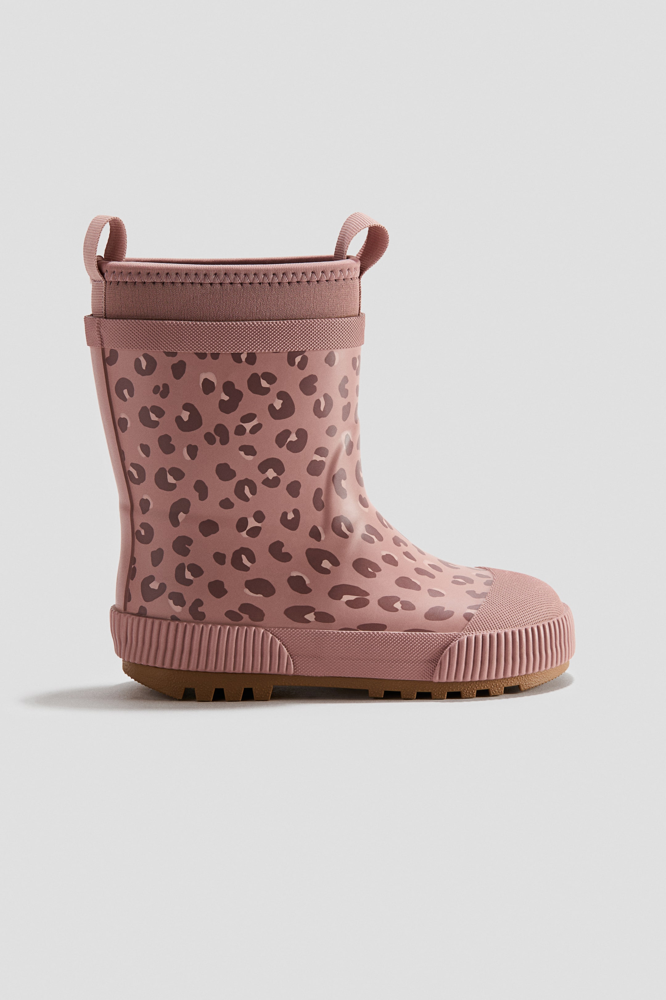 Grösseres Bild ansehen: Der rosafarbene Stiefel zeigt ein dunkelrosa Leopardenmuster und verfügt über zwei Zuglaschen sowie einen gerippten elastischen Schaftabschluss am oberen Rand, darunter ein gewebtes Band. Zudem ist er mit einer runden Zehenpartie und einer profilierten Sohle mit braun strukturierter Aussensohle ausgestattet.