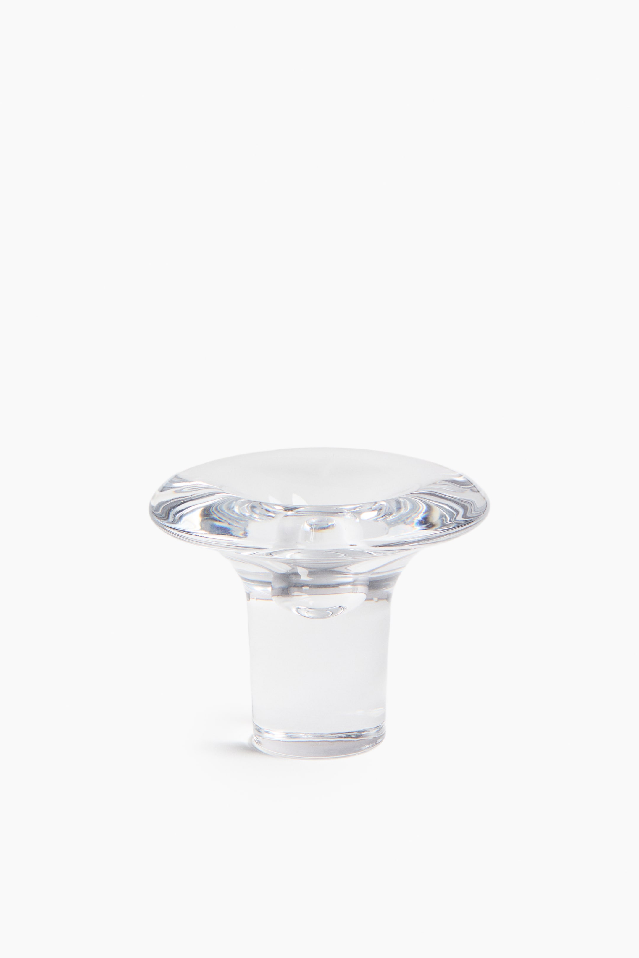 View larger image: A clear glass candle holder is shown from the FRONT. It features a wide, smooth top with a central depression, flaring out above a cylindrical base.