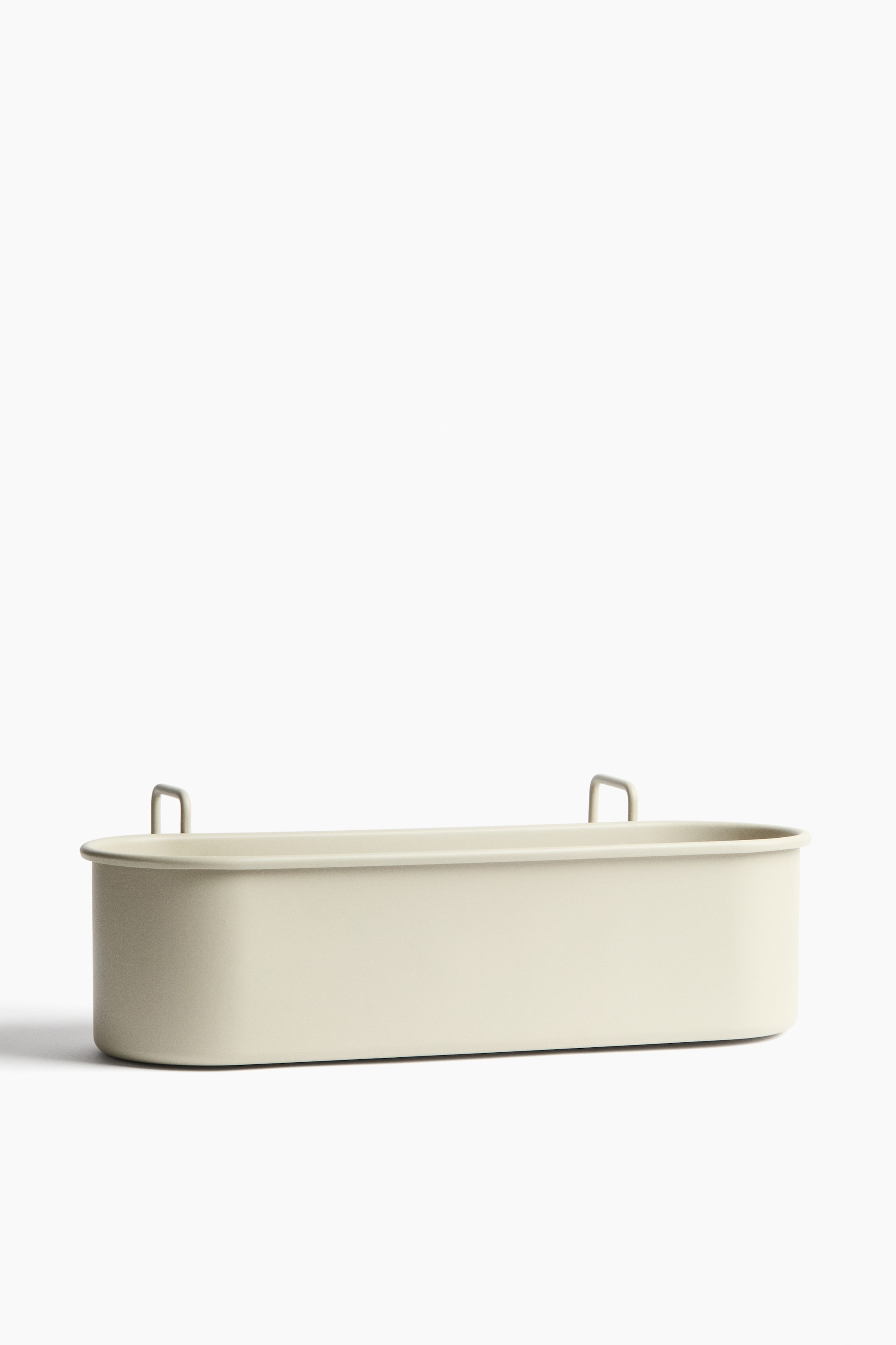 Agrandir l'image: Un long conteneur rectangulaire de couleur beige clair est orienté FACE, avec des coins arrondis et une finition lisse et mate. Il présente deux crochets en forme de U s'élevant de son bord supérieur, un près de chaque extrémité.