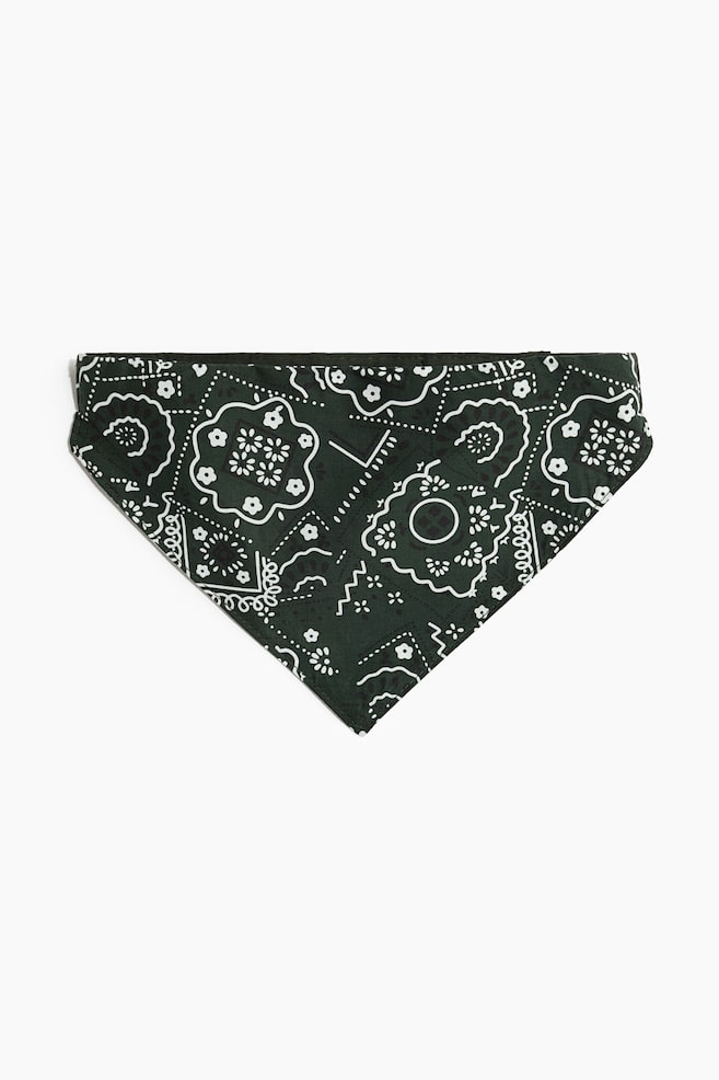 Een donkergroene bandana ligt plat en toont een driehoekige vorm met de punt naar beneden aan de voorkant. De stof heeft een verfijnd paisley-patroon in wit en zwart met bloemmotieven. - 1