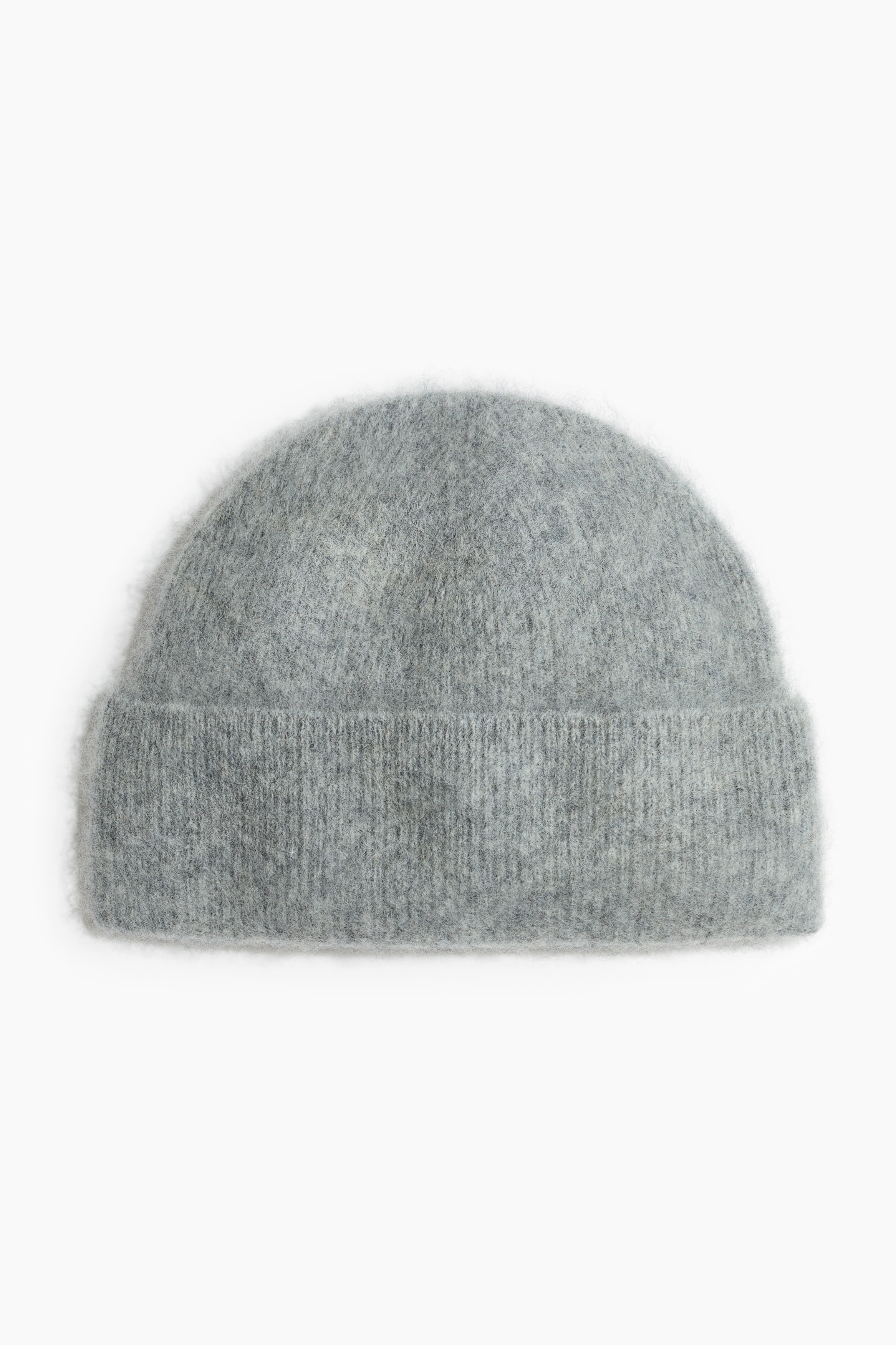 Jasnoszara czapka beanie z miÄkkiej dzianiny o szczotkowanym wykoÅczeniu i z podwiniÄtym brzegiem jest noszona przez modelkÄ. Czapka beanie zostaÅa zestawiona z czarnÄ skÃ³rzanÄ kurtkÄ i biaÅÄ koszulkÄ spod spodu.