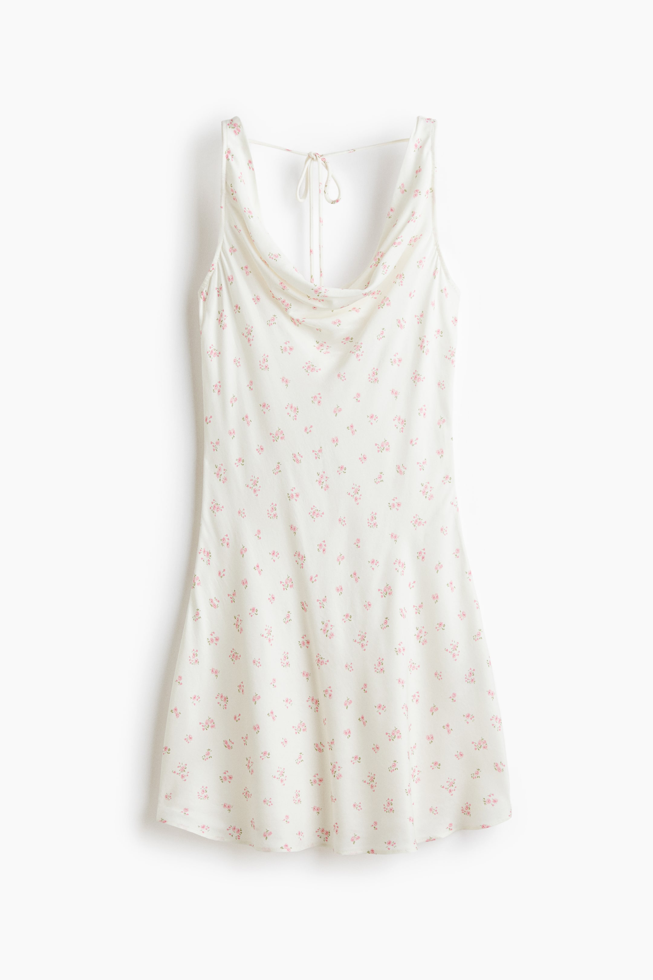 Ver imagen más grande: El vestido mini blanco presenta un estampado floral rosa y un escote drapeado en forma de cowl. Las finas tiras se atan en la espalda, y el vestido fluye en una silueta en línea A.