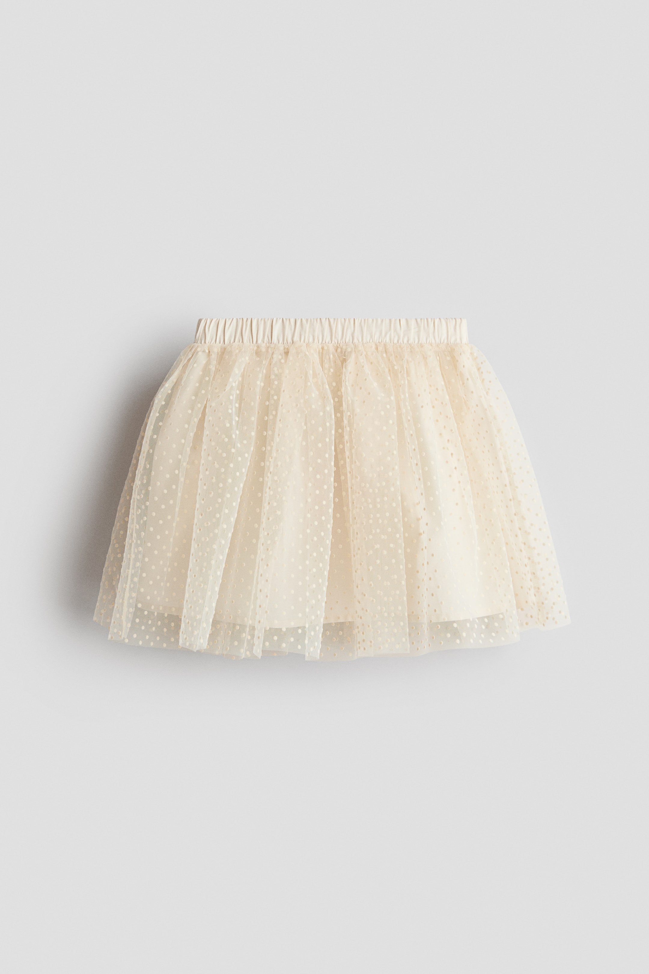 Ingrandisci l'immagine: Una gonna svasata è presentata dal davanti, caratterizzata da un elastico in vita, tulle con pois scintillanti e una fodera opaca sottostante.