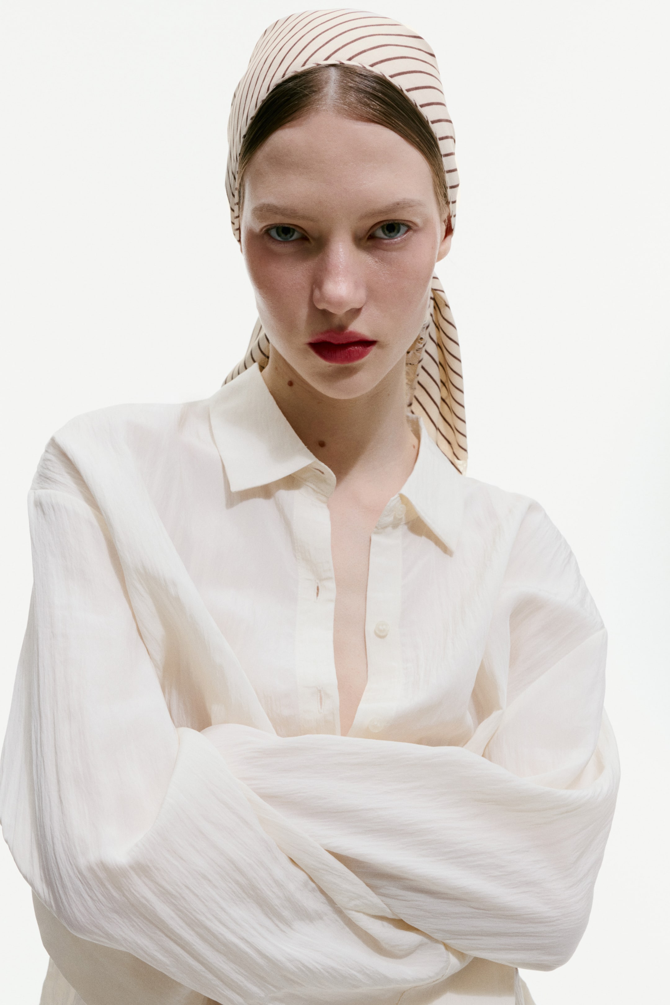 View larger image: A scarf crafted from gently flowing satin showcases slender brown stripes against a light backdrop, elegantly wrapped around the model's head.