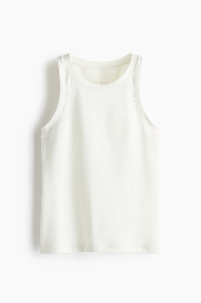 Una blusa sin mangas de color crema estÃ¡ de frente, con cuello redondo alto y tirantes anchos con ribete grueso alrededor del escote y las sisas. La prenda sin mangas muestra una textura suave y cae recta hasta un dobladillo limpio y terminado. - 1