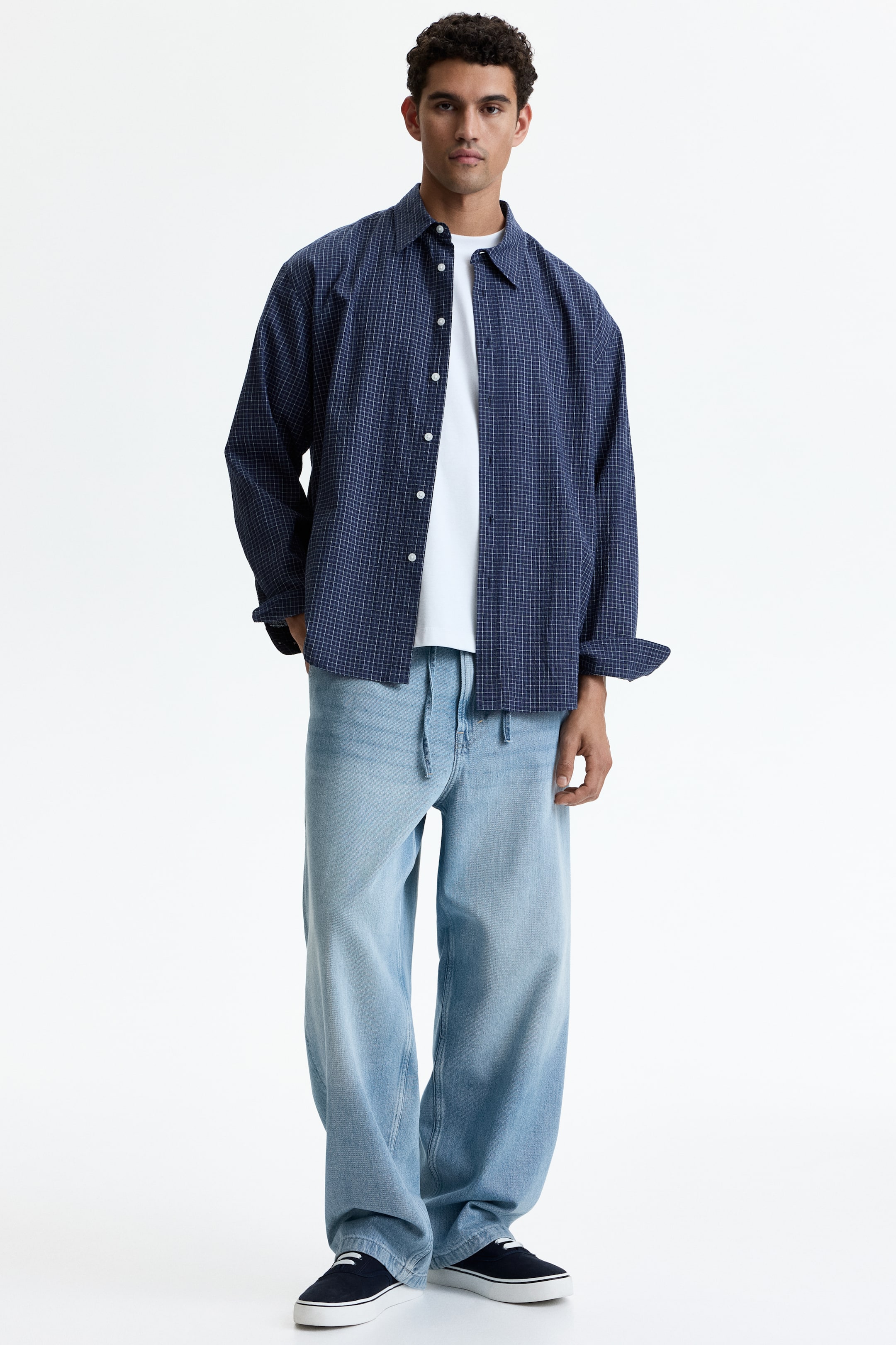 Visa större bild: Ljus tvättade denimjeans, med elastisk dragsko i midjan och en baggy passform med rundade ben, bärs av modellen och staplas vid ankeln.