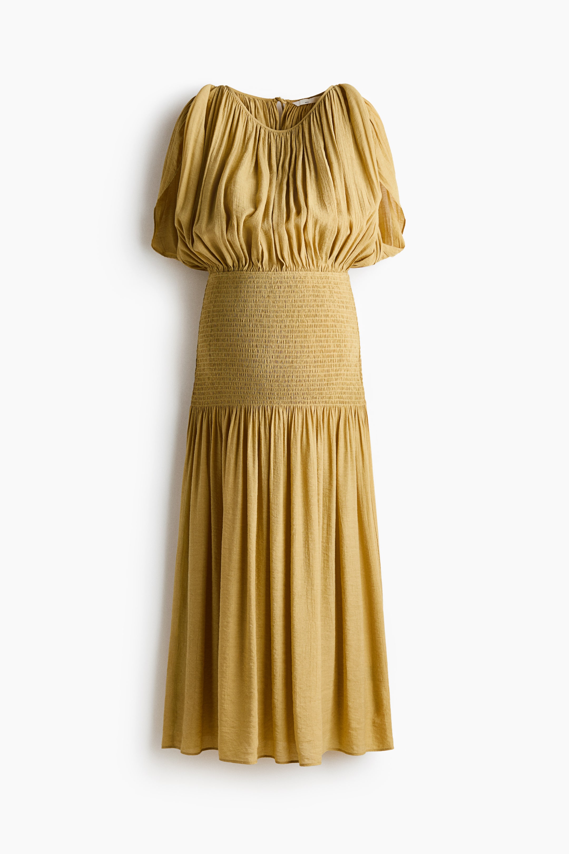 View larger image: A textured mustard yellow maxi dress is showcased from the front. It features a gathered, rounded neckline and short, puffed sleeves. The bodice is loosely gathered, transitioning to a wide shirred waist, with the full-length skirt cascading in soft drapes from a seam below the shirring.