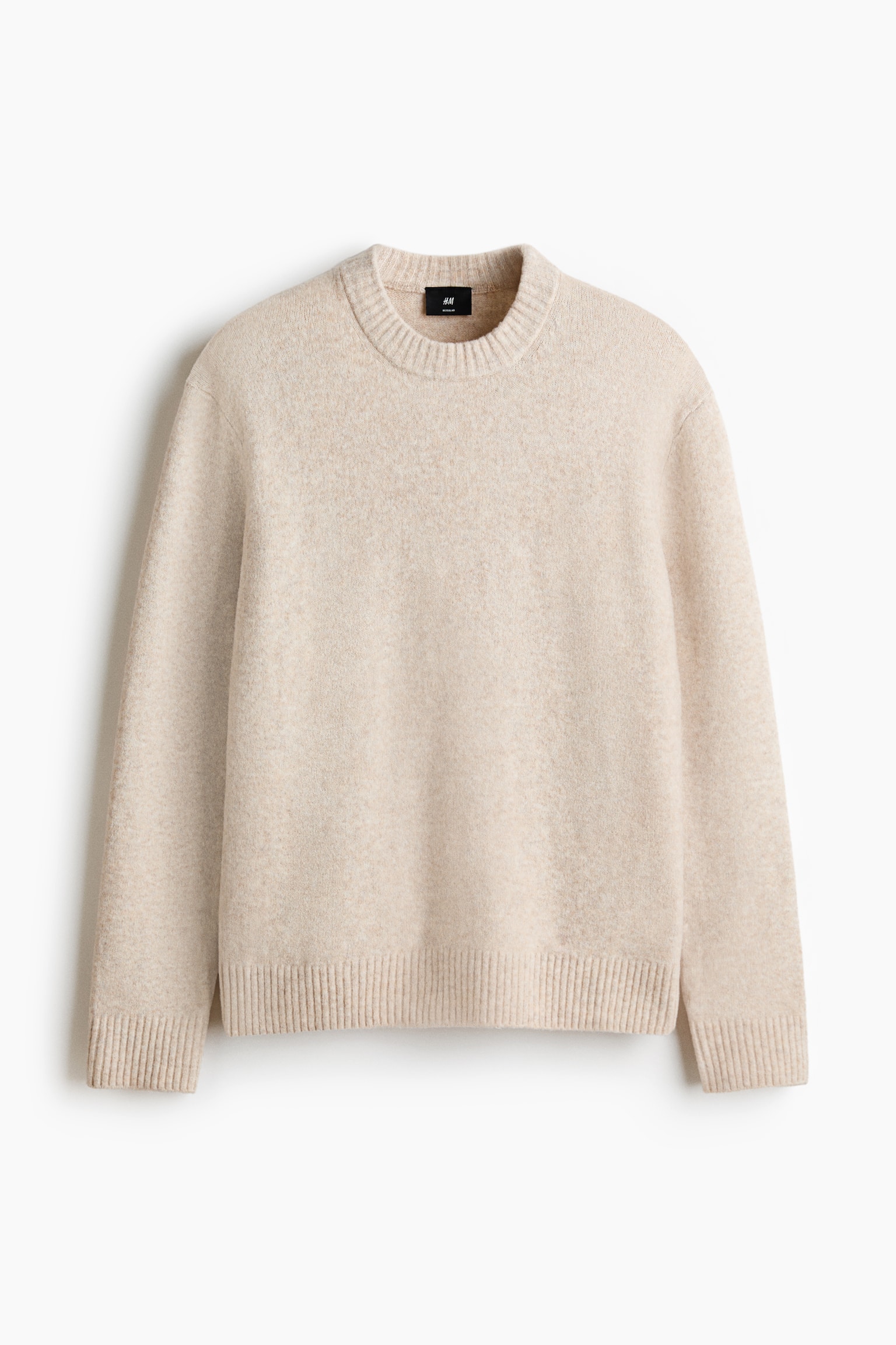 Un suéter beige claro presenta una textura sutil moteada, un cuello redondo acanalado, mangas largas y puños y dobladillo acanalados, presentado desde el frente. - 1