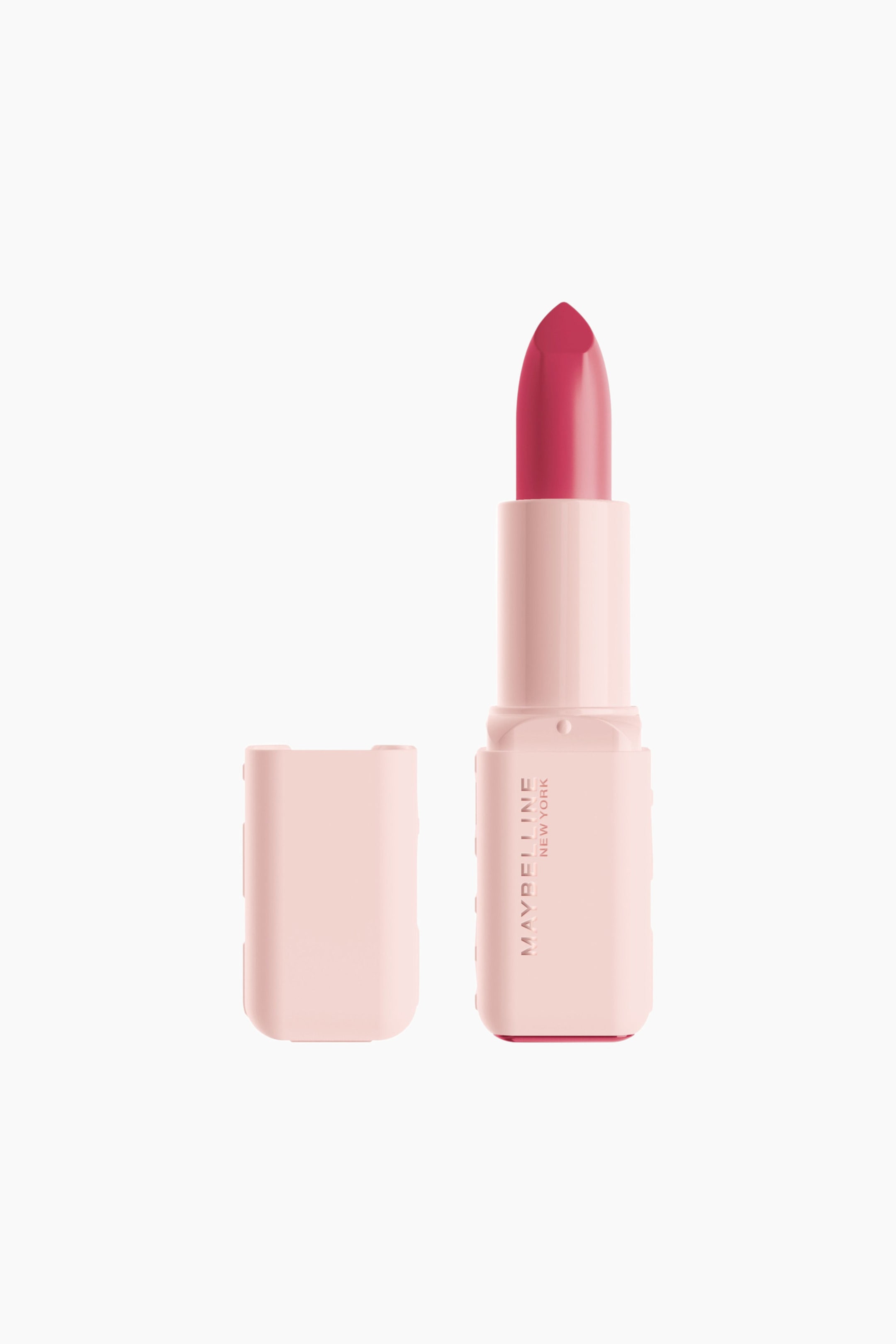 Visa större bild: Ett läppstift står upprätt och visar ett livfullt magentastift med spetsig topp som skjuter upp ur dess ljusrosa, rektangulära hylsa. På hylsan står "MAYBELLINE NEW YORK" vertikalt, och dess matchande ljusrosa lock ligger bredvid till vänster.