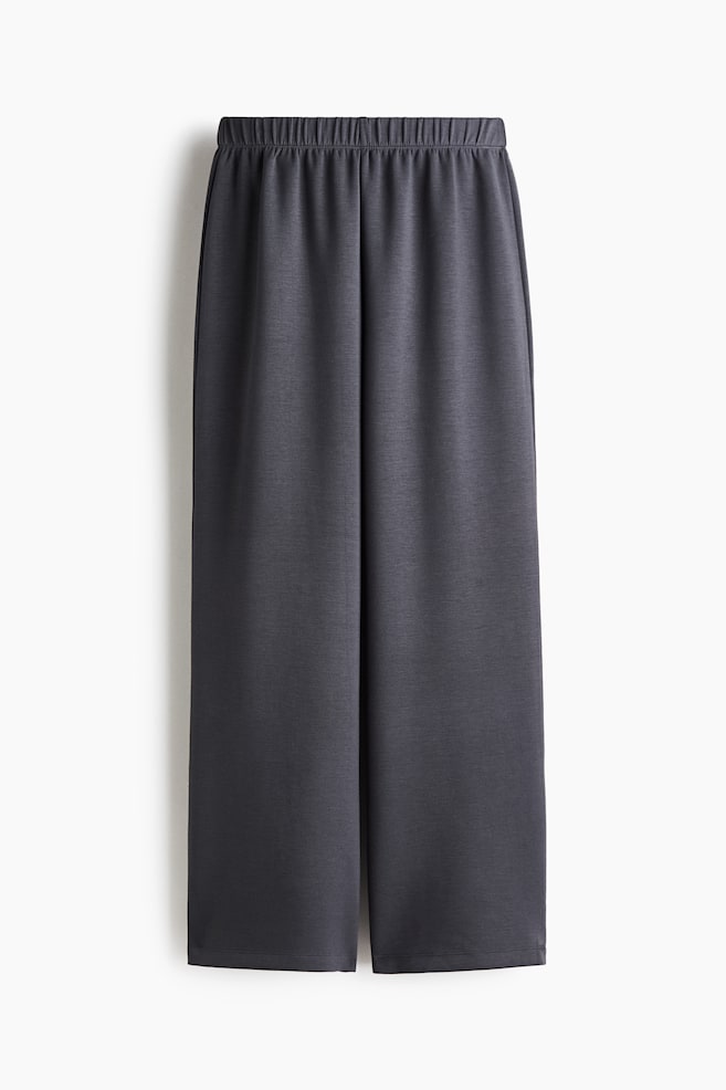 Eine dunkelgraue Wide-Leg-Hose hängt frontal und verfügt über einen gerafften elastischen Bund sowie eine lockere, gerade Silhouette. - 1