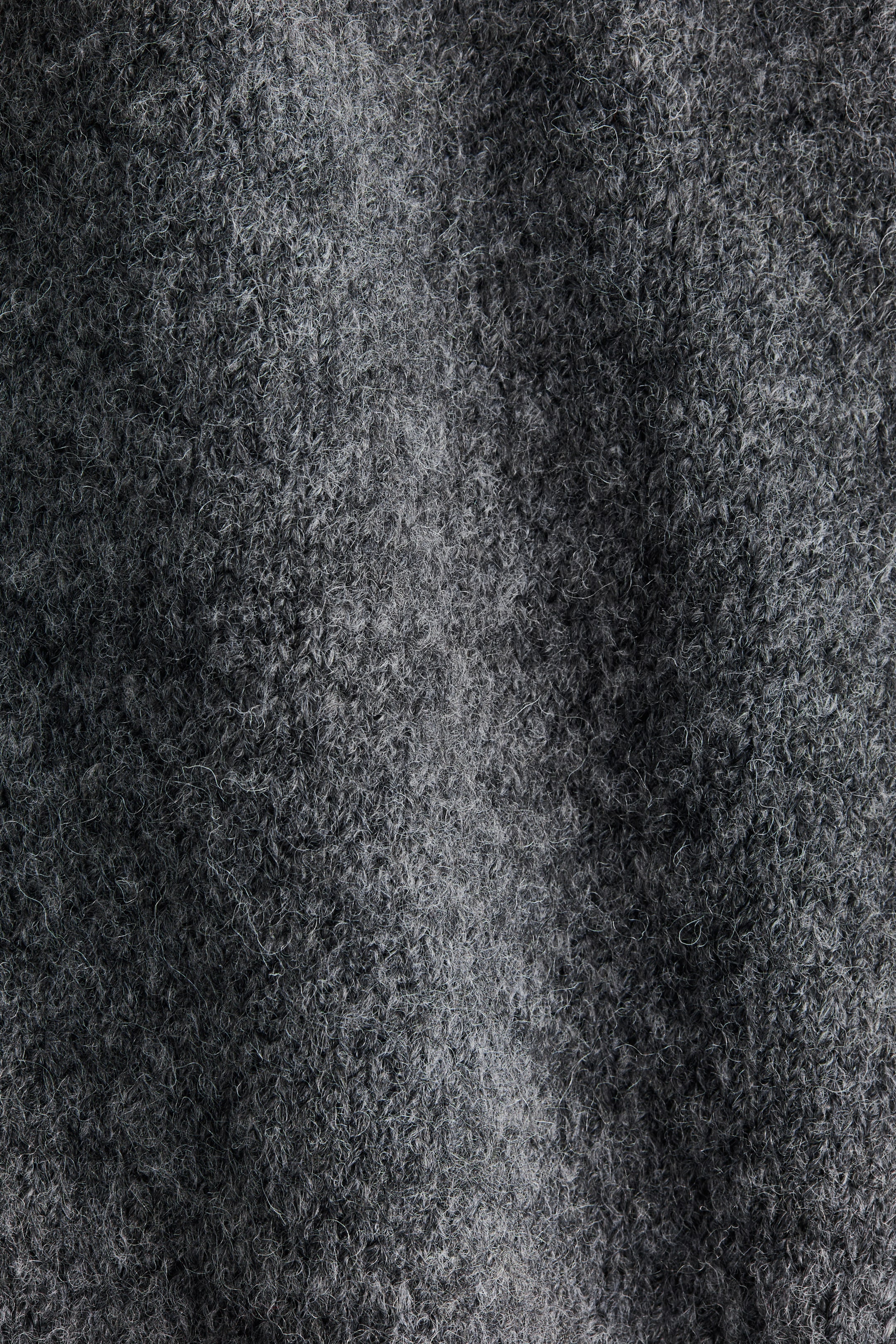 Ver imagen más grande: La tela gris muestra una superficie densamente texturizada y jaspeada. Está presentando fibras entrelazadas, creando una apariencia suave, ligeramente afelpada con sutiles variaciones en el tono.