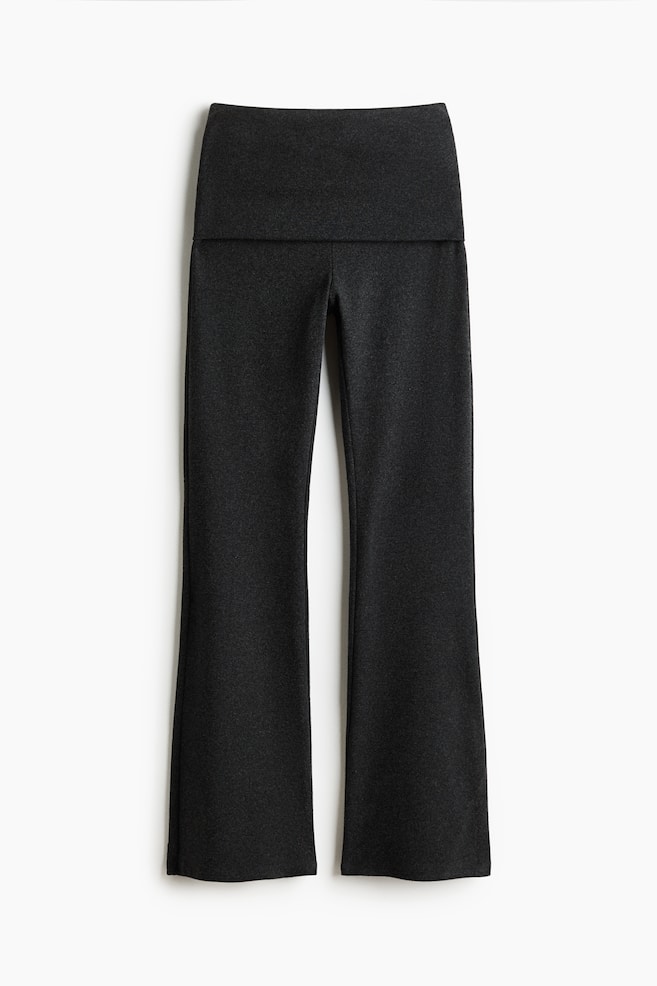 These dark charcoal grey trousers are shown from the front, featuring a wide fold-over waistband and legs that flare slightly towards the hem. - 1