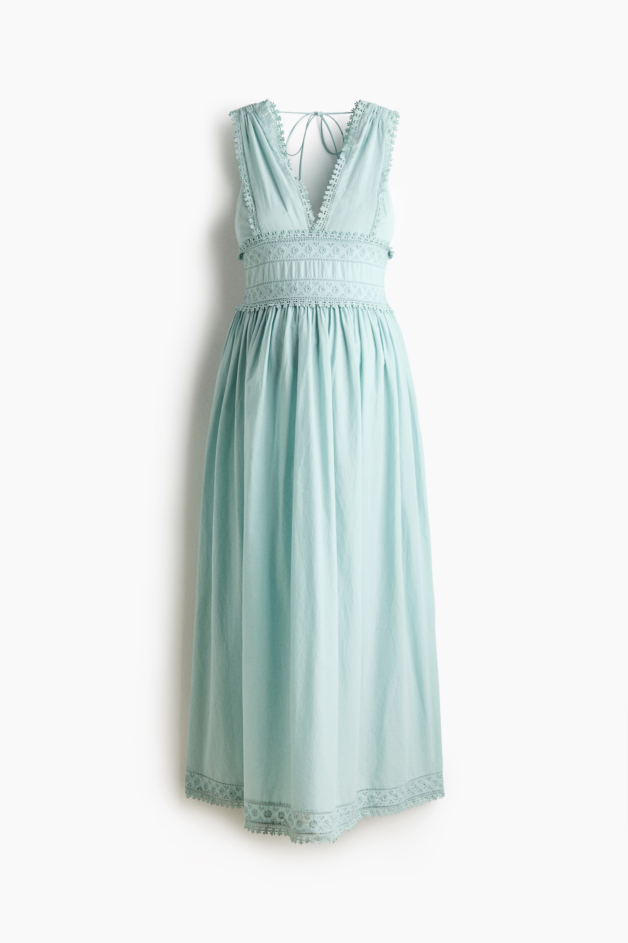 Agrandir l'image: Une longue robe d'allaitement sans manches en tissage de coton bleu clair présente un corsage ajusté avec un décolleté en V profond à l'avant et à l'arrière. Elle est dotée de liens étroits à nouer à l'arrière du cou, de fronces à la taille et d'une jupe légèrement évasée, le tout orné de bordures en dentelle et de broderie anglaise.
