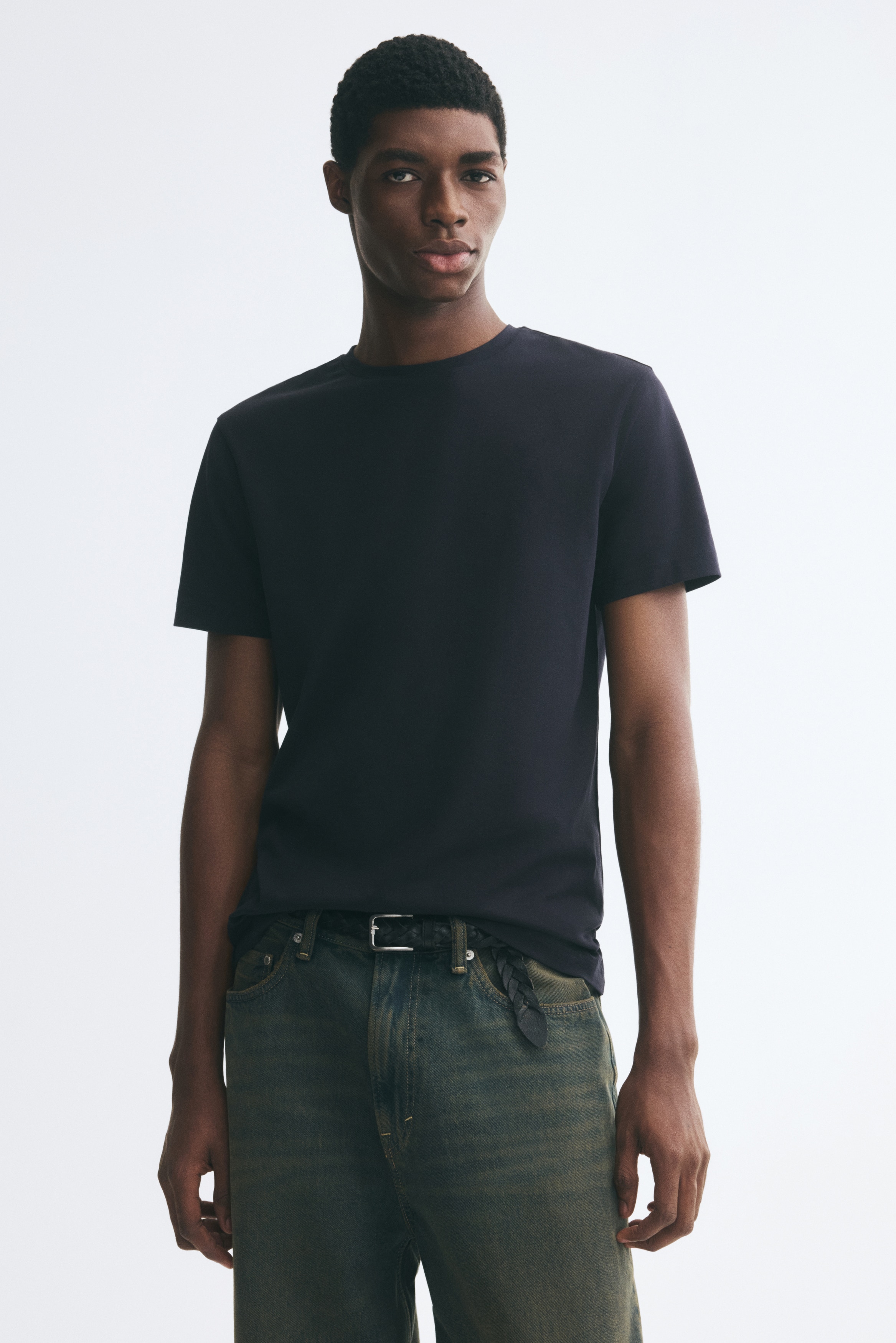 ÎÎ½Î± ÏÎºÎ¿ÏÏÎ¿ Î¼ÏÎ»Îµ navy T-shirt ÏÎ±Î¯Î½ÎµÏÎ±Î¹ Î±ÏÏ Î¼ÏÏÎ¿ÏÏÎ¬, Î¼Îµ ÏÏÏÎ¿Î³Î³ÏÎ»Î® Î»Î±Î¹Î¼ÏÎºÎ¿ÏÎ·, ÎºÎ¿Î½ÏÎ¬ Î¼Î±Î½Î¯ÎºÎ¹Î± ÎºÎ±Î¹ Î¯ÏÎ¹Î¿ ÏÎµÎ»ÎµÎ¯ÏÎ¼Î±. Î¤Î¿ slim-fit ÏÎ¿ÏÏÎ¿ ÏÎ±ÏÎ¿ÏÏÎ¹Î¬Î¶ÎµÎ¹ Î»ÎµÎ¯Î±, Î¼Î¿Î½ÏÏÏÏÎ¼Î· ÏÏÎ® Î¼Îµ Î¼Î¹Î½Î¹Î¼Î±Î»Î¹ÏÏÎ¹ÎºÏ ÏÏÎµÎ´Î¹Î±ÏÎ¼Ï.