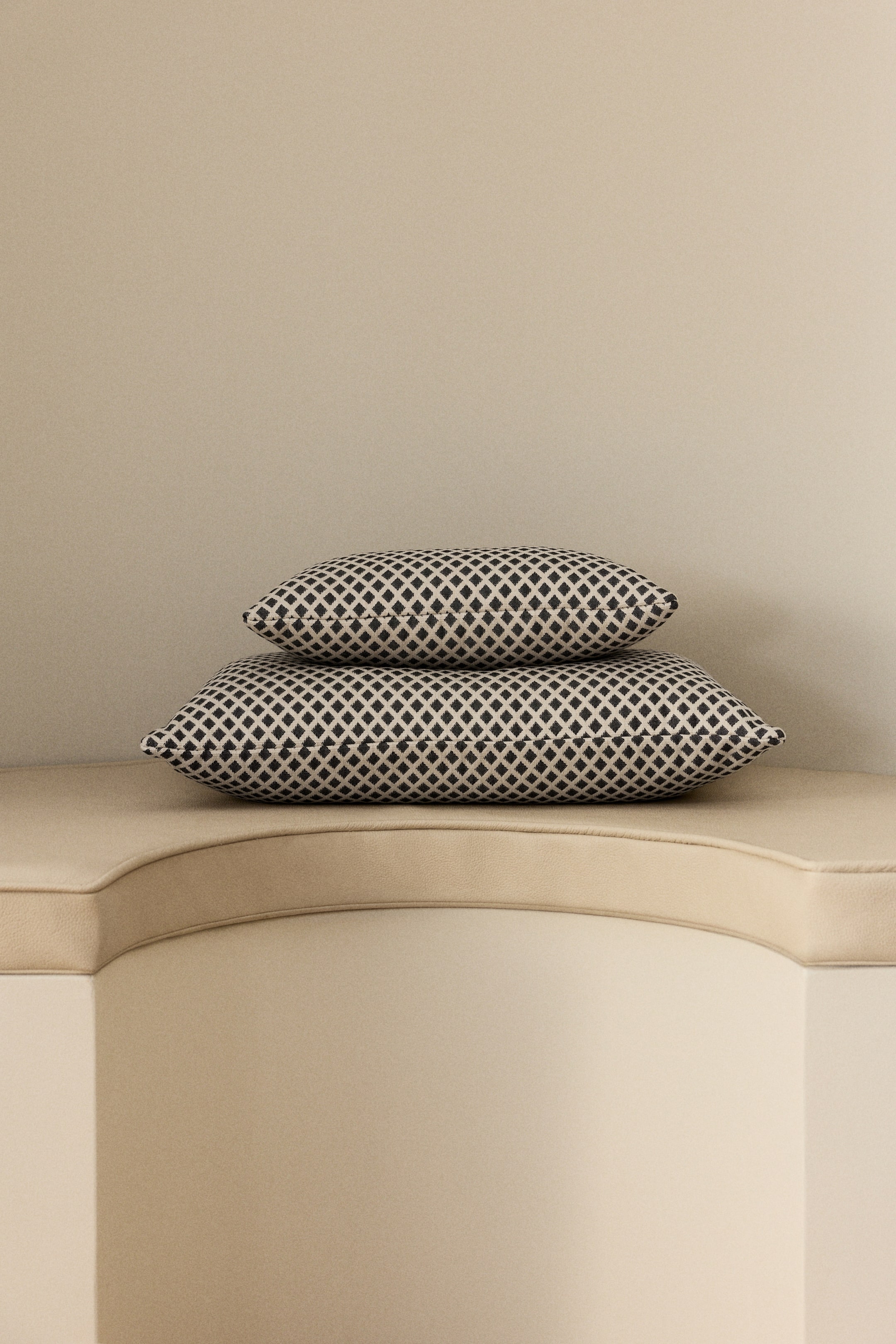 View larger image: Two pillows are stacked, one on top of the other, each showcasing a repeating black and off-white diamond pattern. The pillows are displaying their rectangular shape from a front-facing angle.
