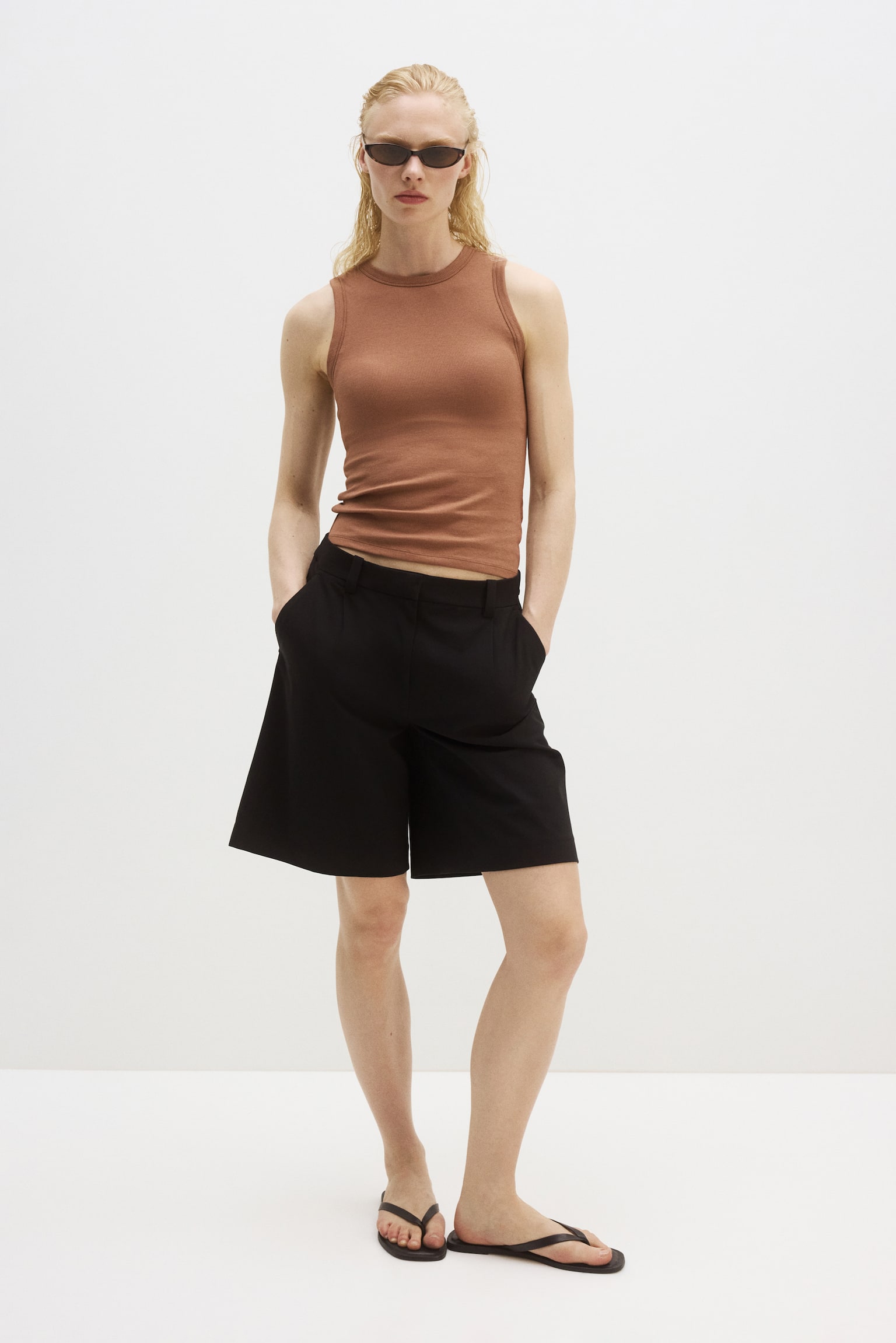 A brown ribbed vest is presented facing front. It features a crew neck, finished armholes, and a straight hem. - 1