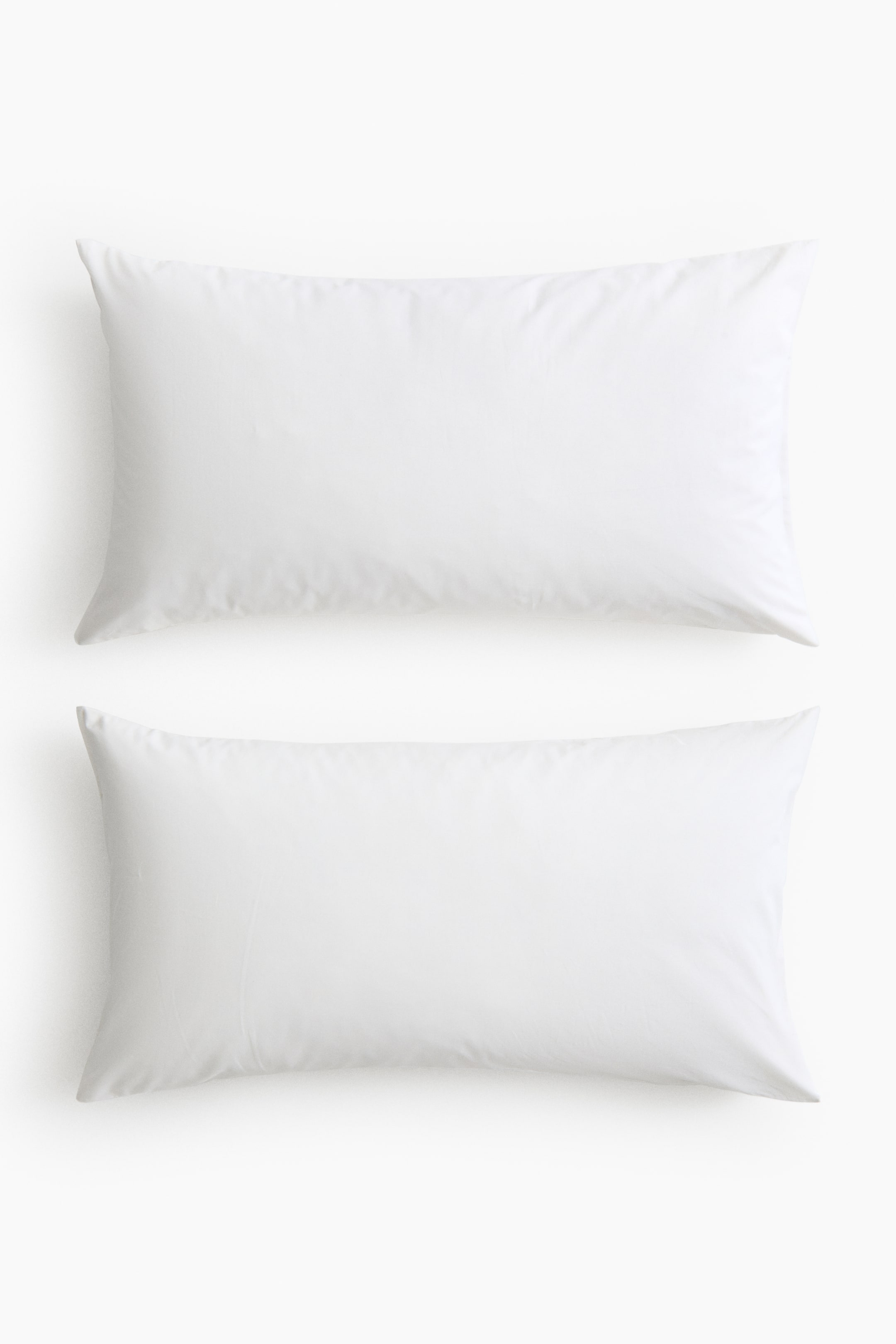 View larger image: A pair of white pillowcases presents a smooth, rectangular form, lying flat with gentle folds.