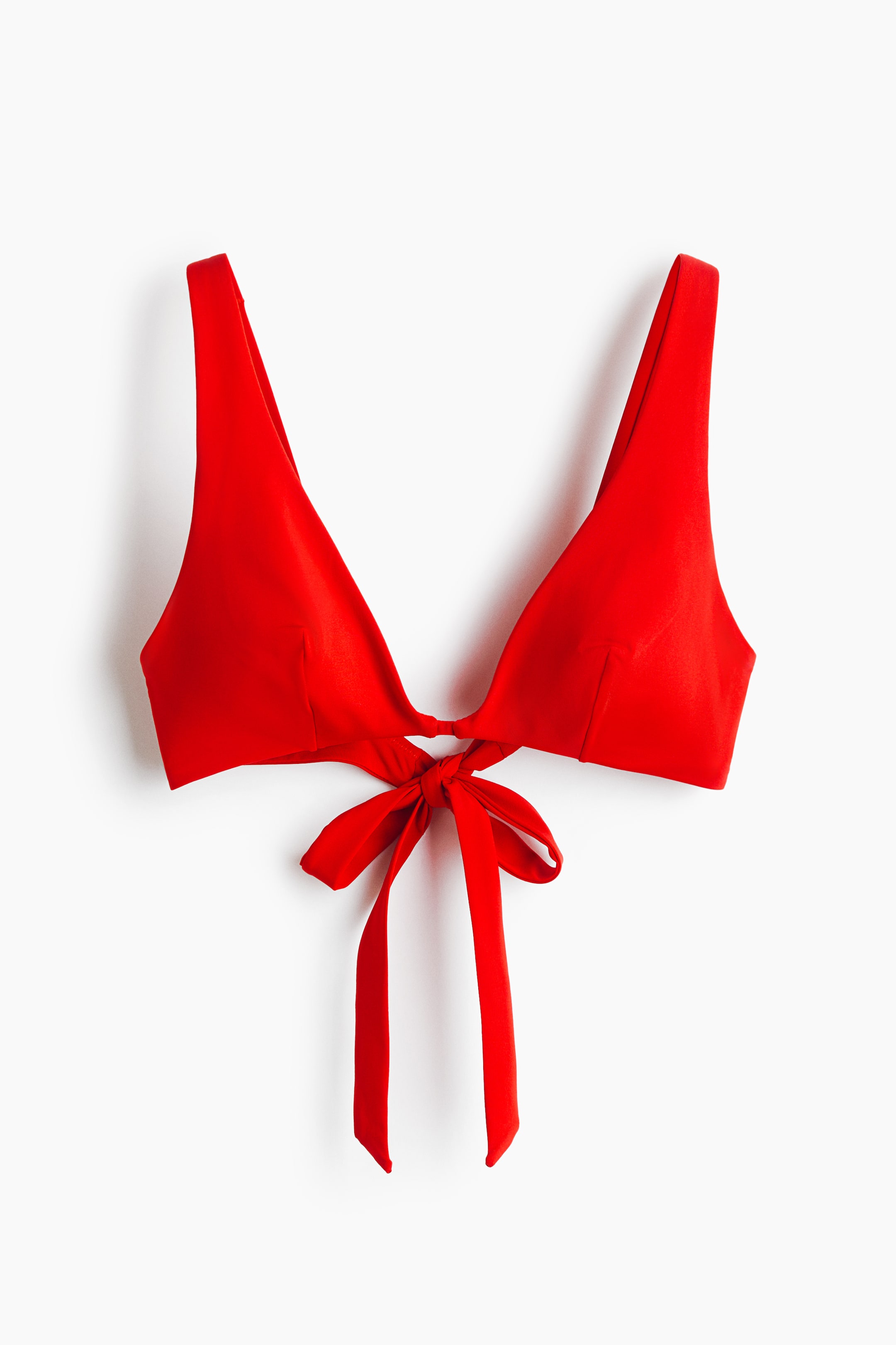View larger image: A red bikini top is showcased in a front view, featuring two triangular cups connected by a central tie knot with long ties hanging down. It also displays wide shoulder straps.