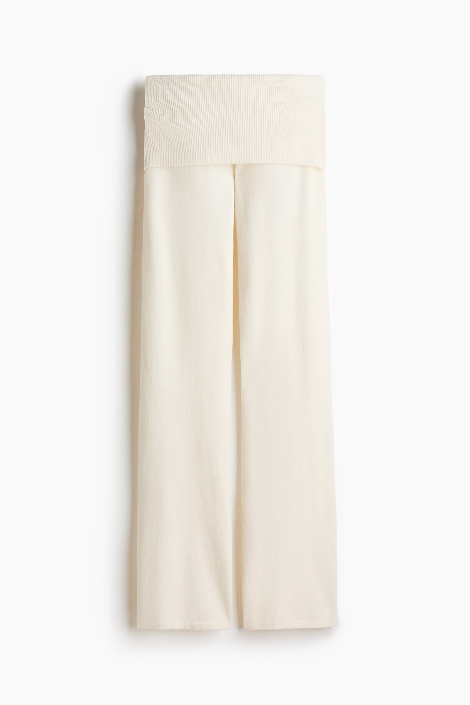 Un pantalon en maille de couleur crème est suspendu, vu de face, avec une large ceinture rabattue côtelée et des jambes droites légèrement évasées, confectionné dans une maille douce et texturée. - 1