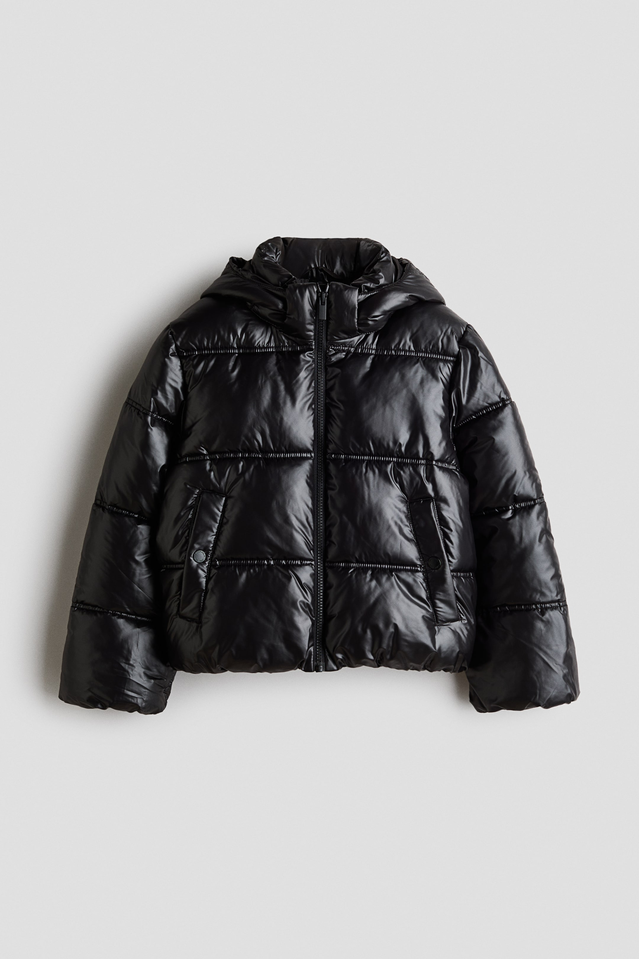 Se større billede: En sort dunjakke med en blank finish og et quiltet design med både vandrette og lodrette syninger, set forfra. Den har en fastsyet hætte, en central lynlåslukning og to frontlommer, hvoraf den ene har en trykknapdetalje.