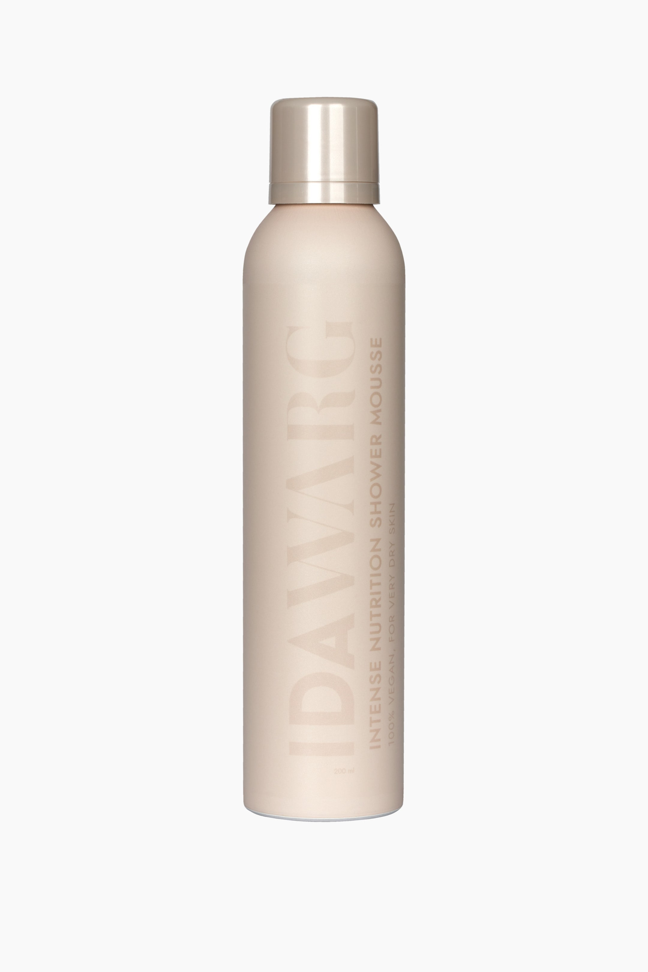 Se større billede: En lys ferskenfarvet cylindrisk aerosol dåse står oprejst og vender fremad, med en metallisk hætte. Dåsen viser "IDAW�RG" lodret i store bogstaver, med "INTENSE NUTRITION SHOWER MOUSSE", "100% VEGAN. FOR VERY DRY SKIN", og "200 ml" skrevet nedenunder i mindre lodret tekst.