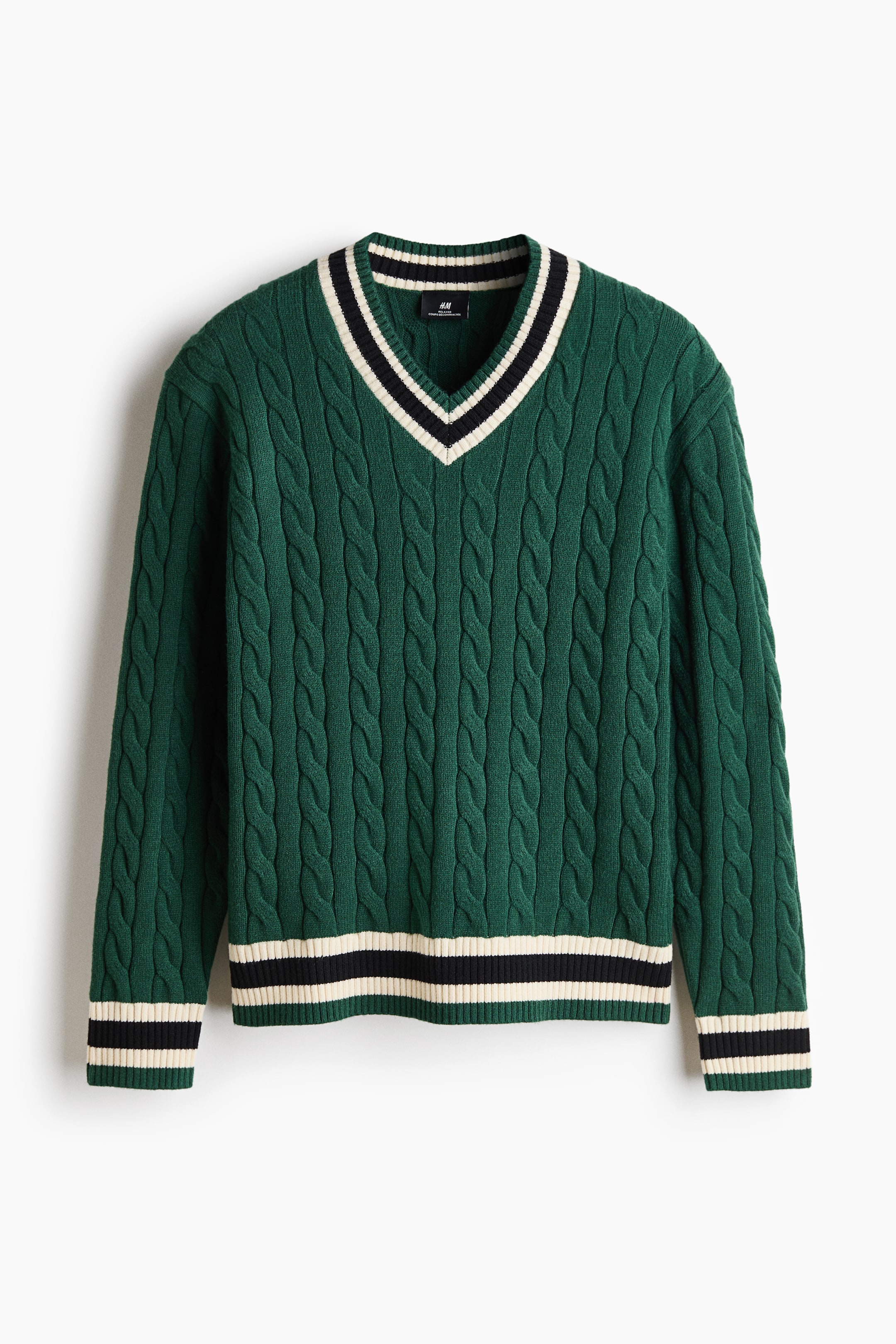 View larger image: A green cable-knit sweater is shown from the front, highlighting its V-neckline with black and off-white striped ribbed trim. The sweater features matching striped ribbed cuffs and a striped ribbed hem.